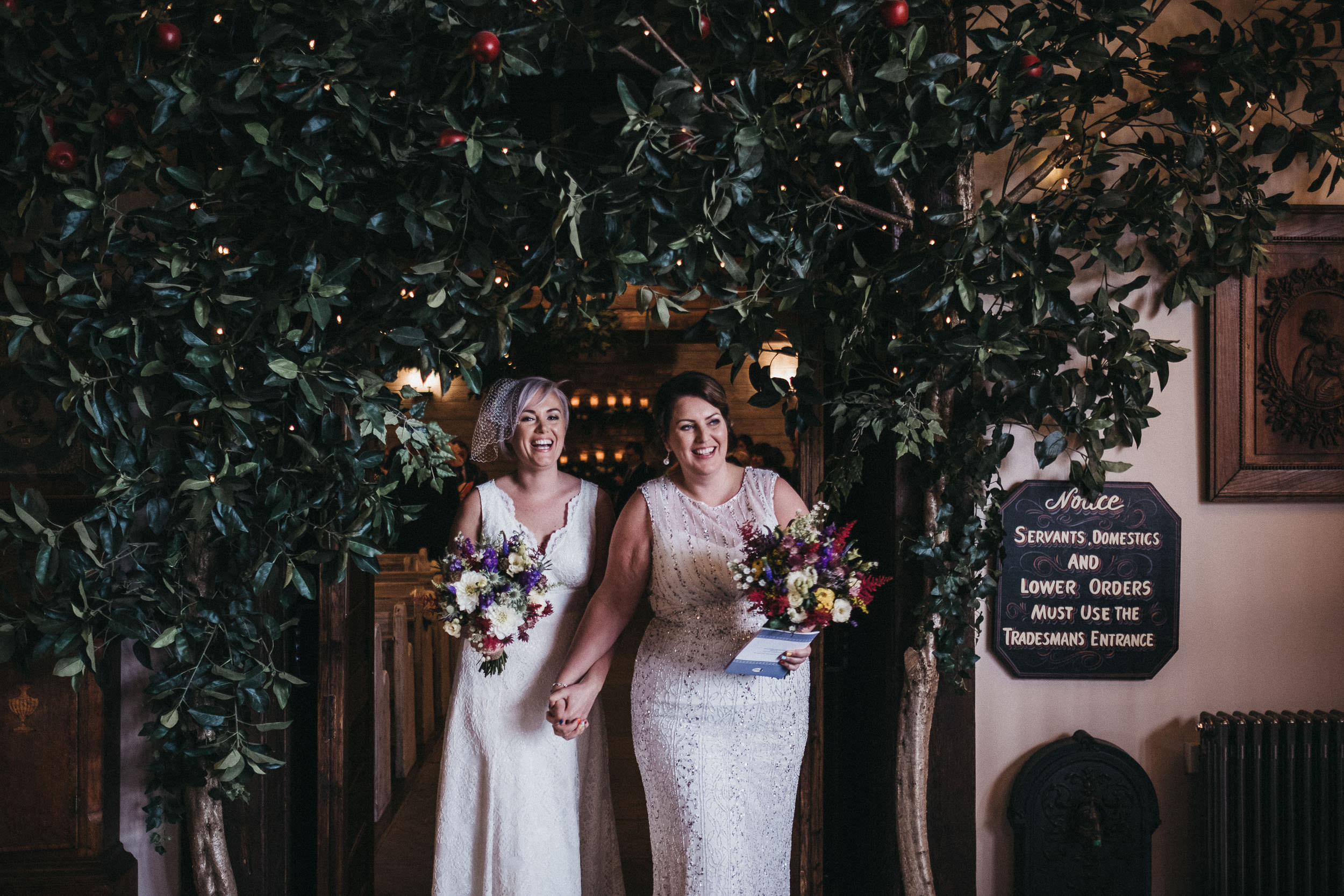 BTwo brides emerge smiling from their wedding ceremony