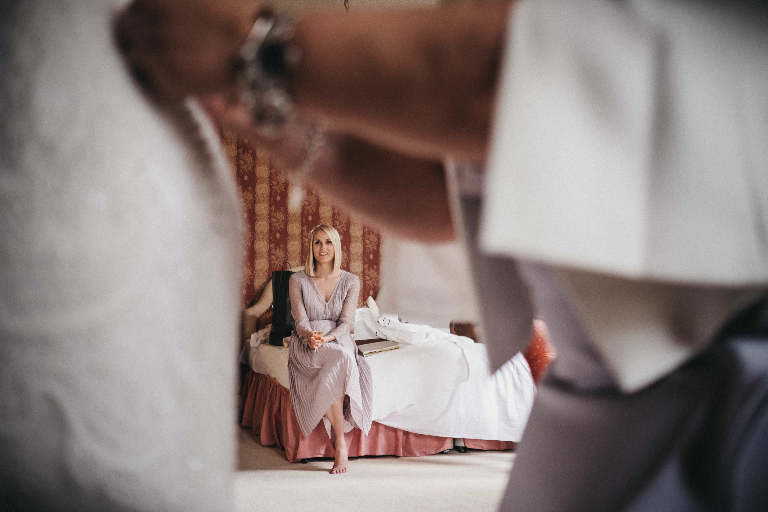 Bridesmaid watches as bride gets ready