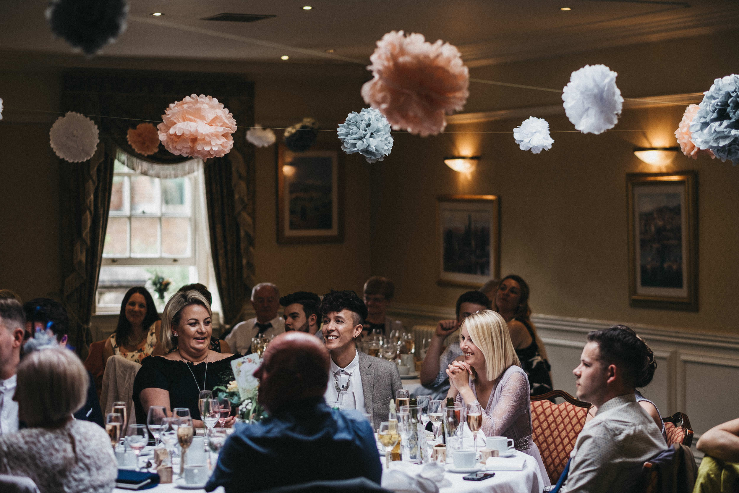 Smiling wedding guests watch speeches