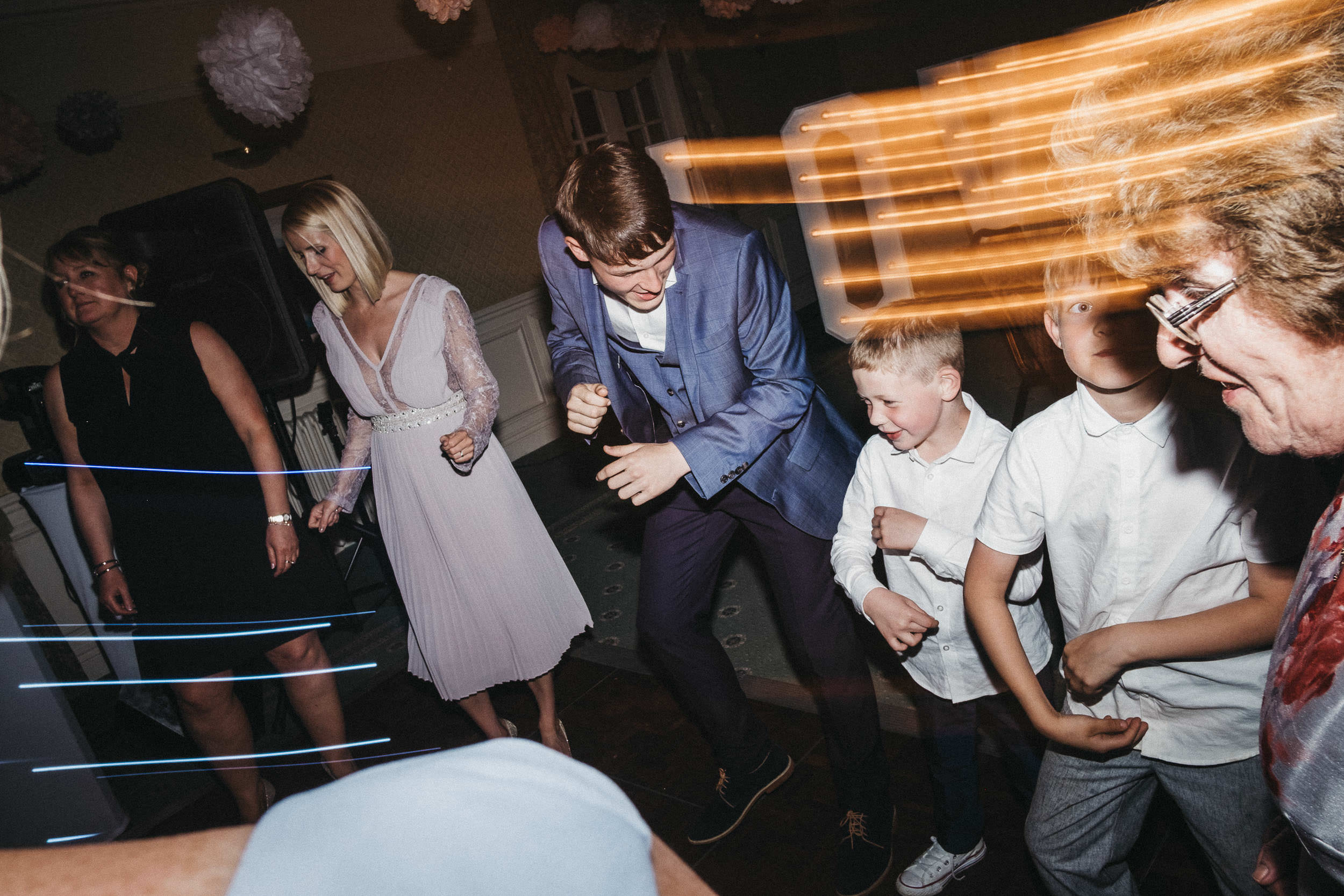 Page boys and guests dancing at wedding