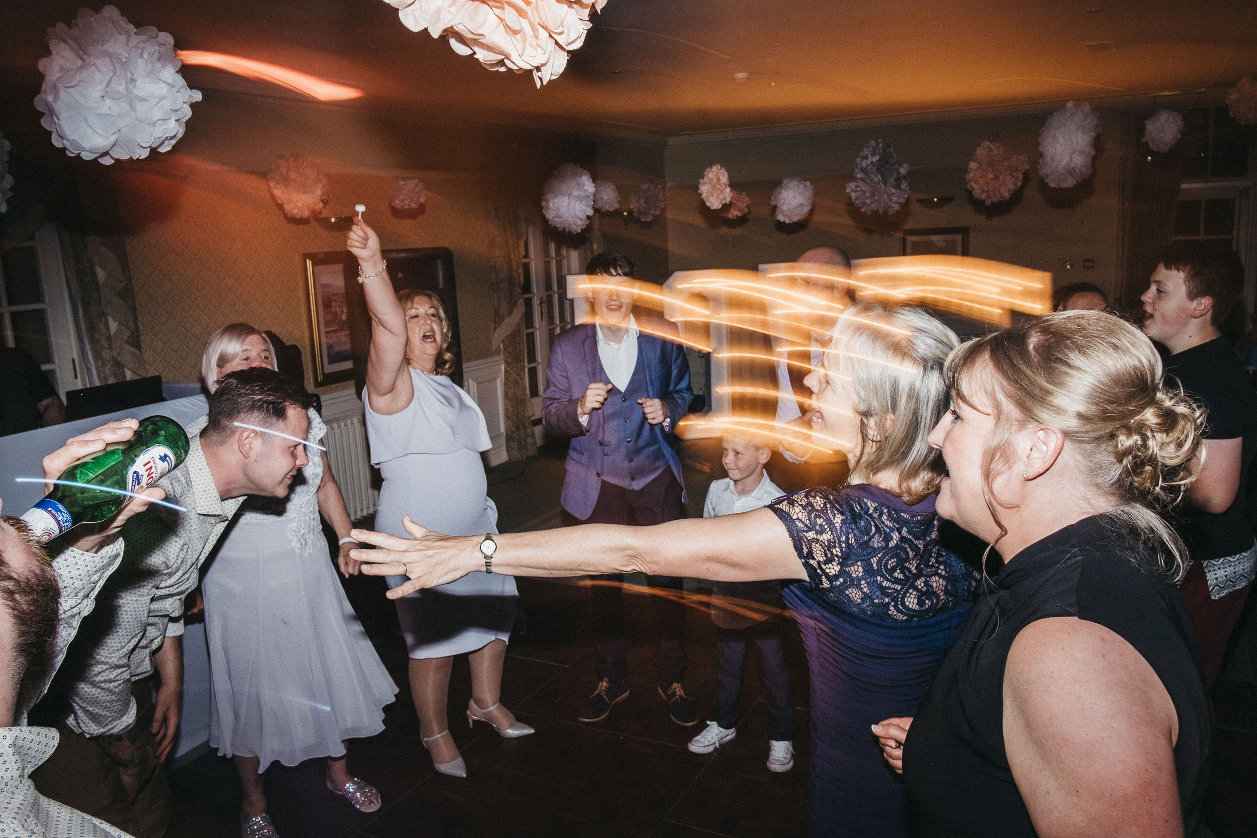Wedding guests dancing energetically at wedding