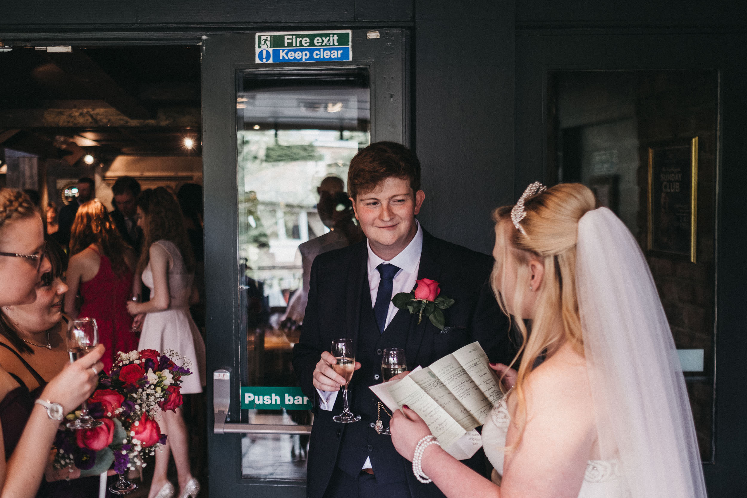 Bride reads wedding certificate while groom looks on
