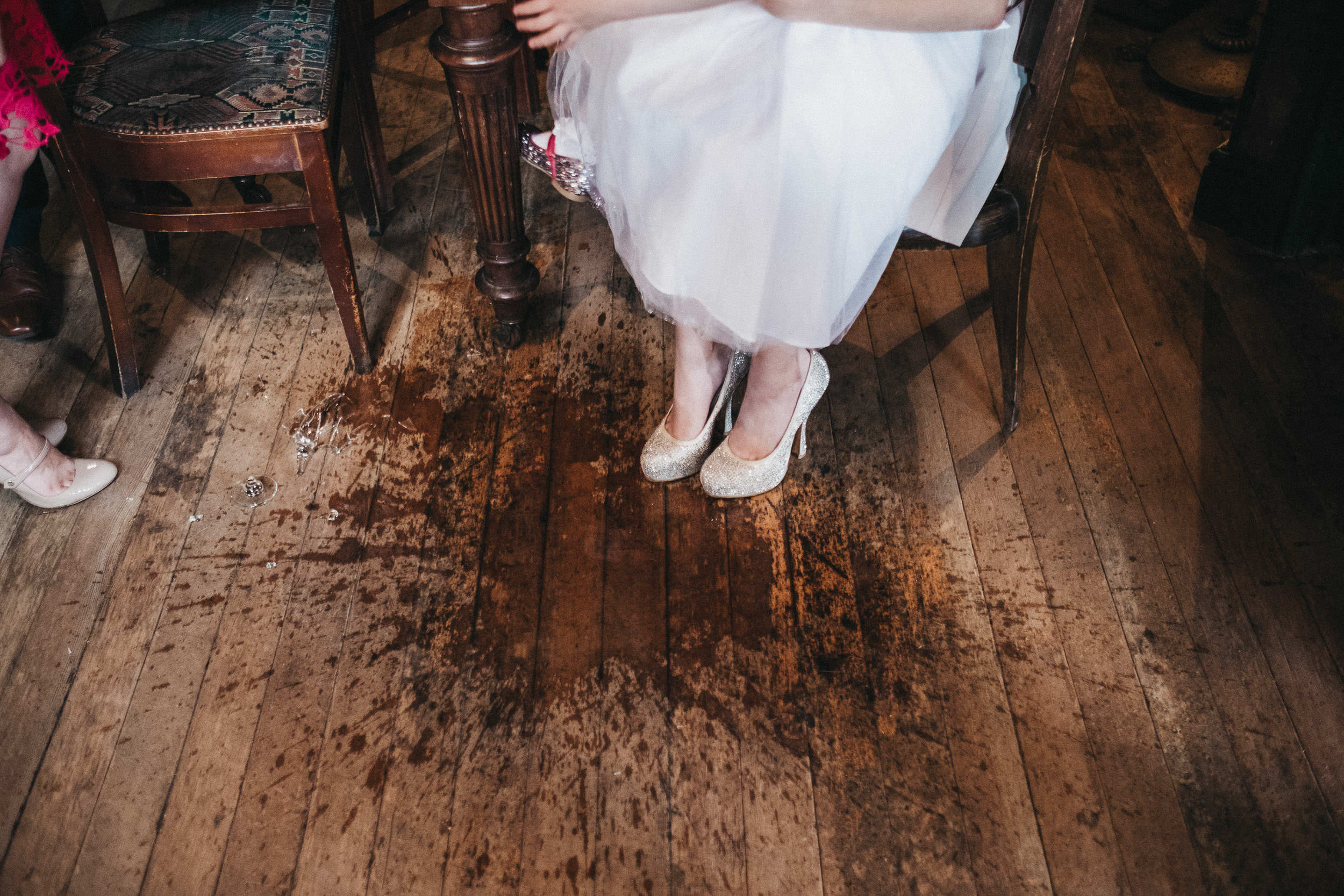 Guest sits with glitter covered shoes in spilt drink