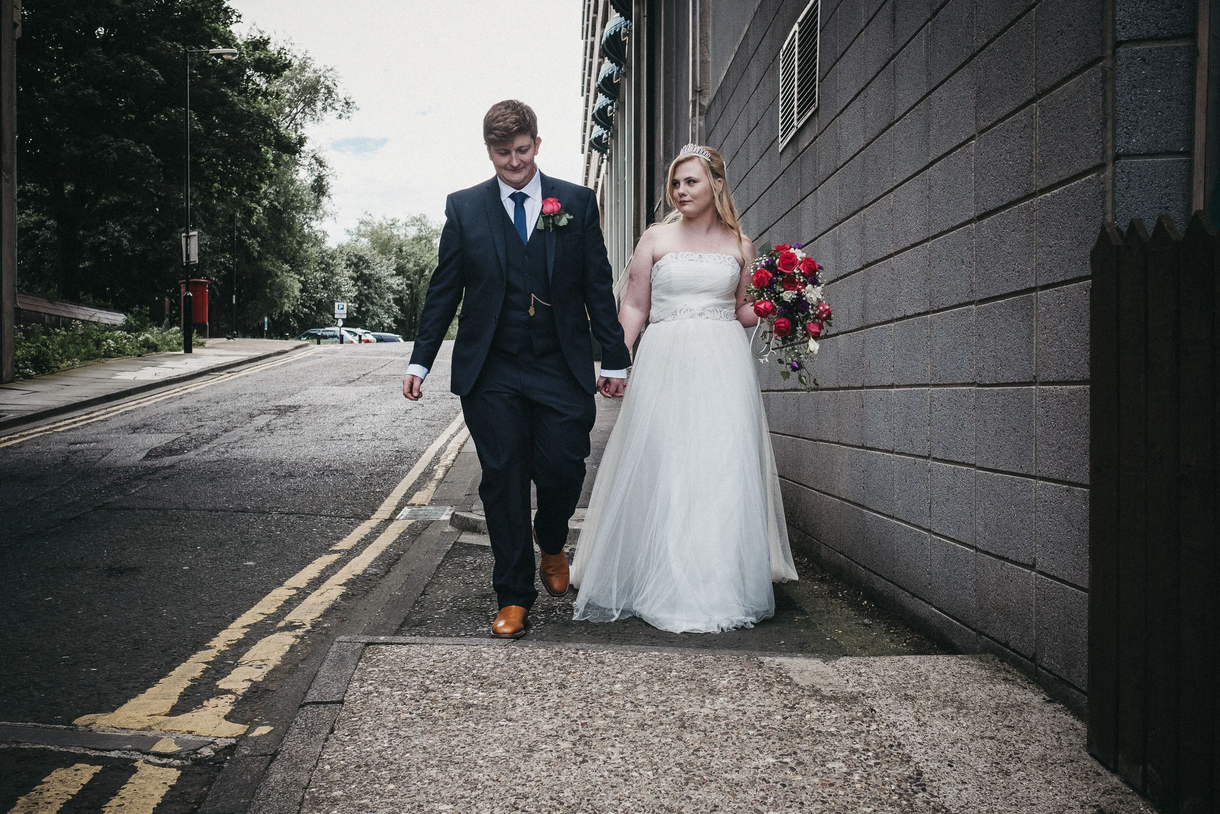 Bride and room walk hand in hand outside As You Like It