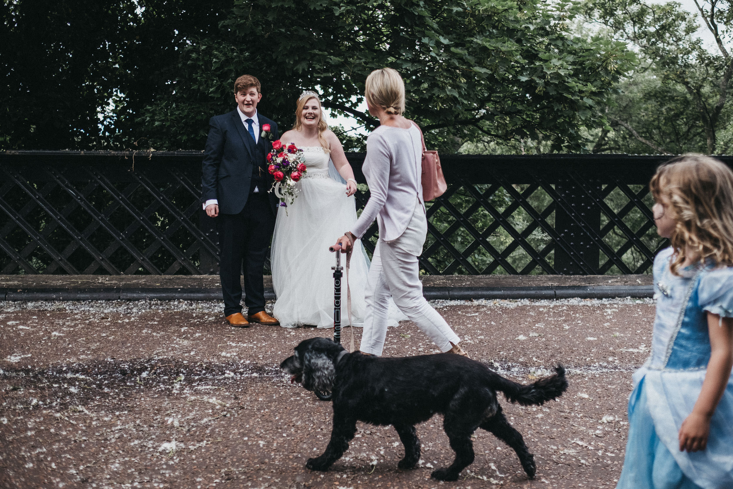 Bride and groom talk to passerby on Armstrong Bridge