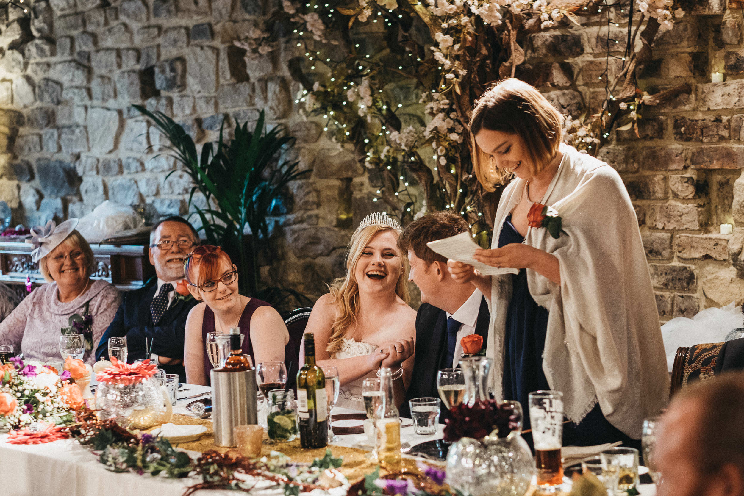 Bride and groom laugh during wedding speeches