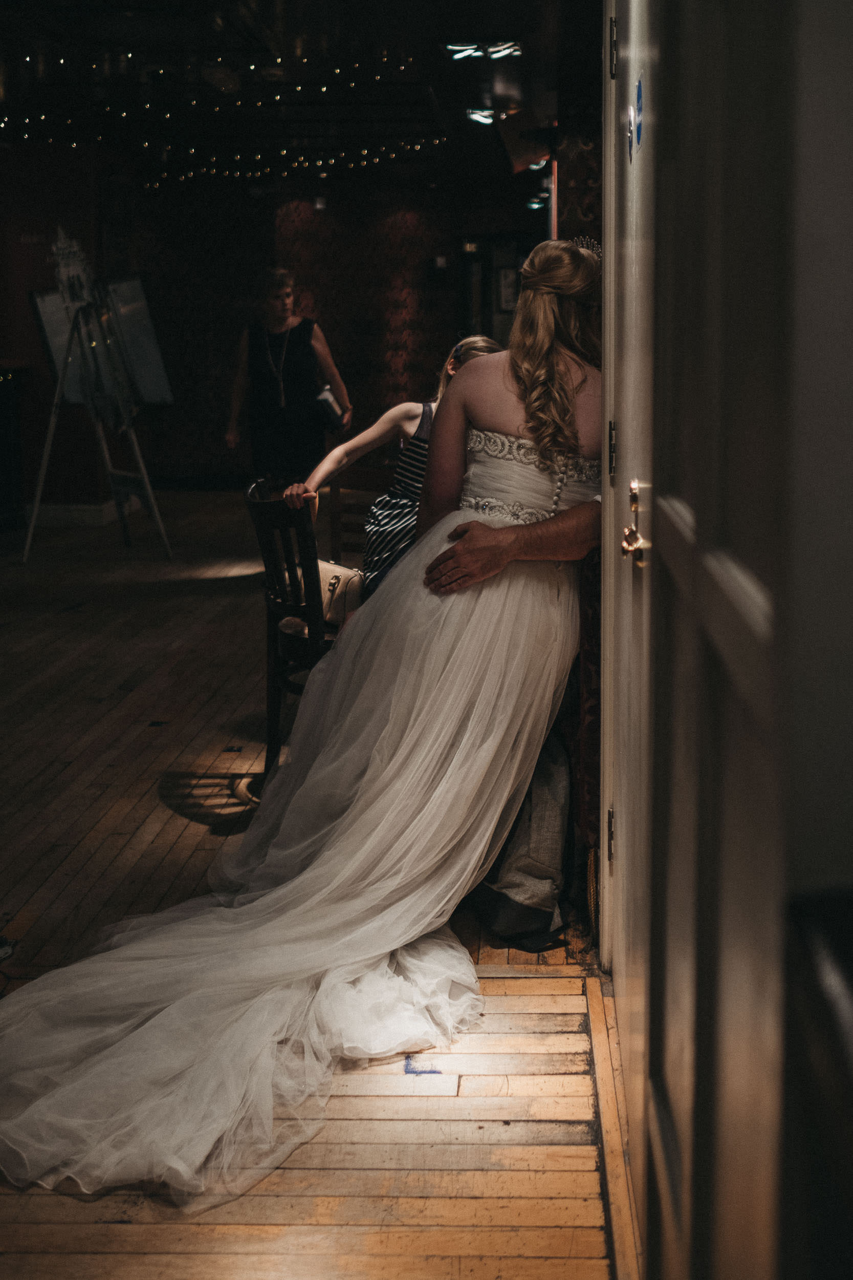 Bride sits on wedding guest's knee at As You Like It