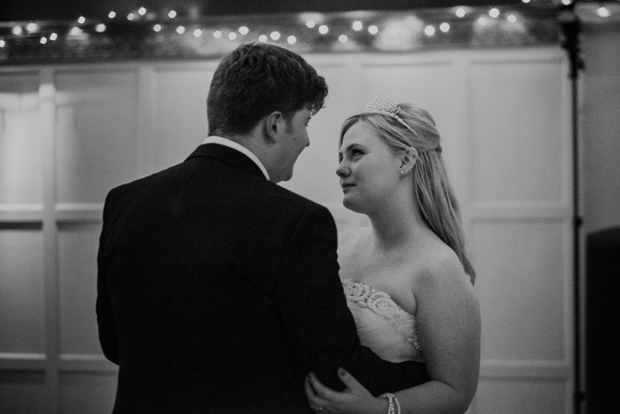 Black and white photo of bride looking intensely at groom during first dance