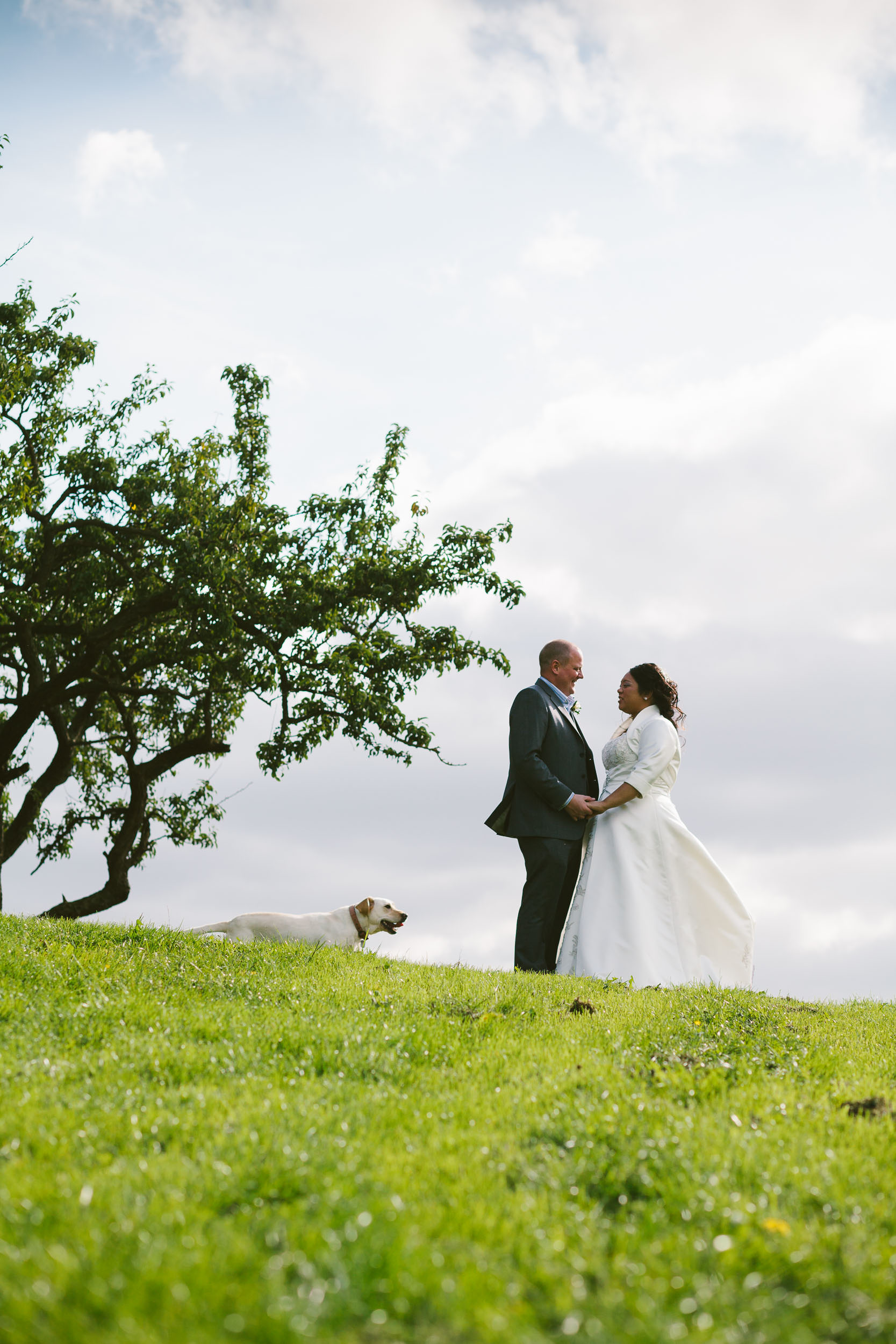 Bride and groom in romantic pose while dog photo bombs them