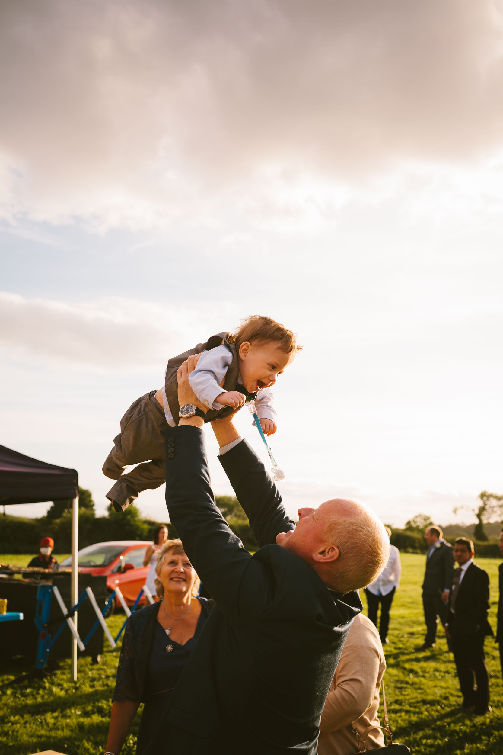 Wedding guest throws laughing baby in the air