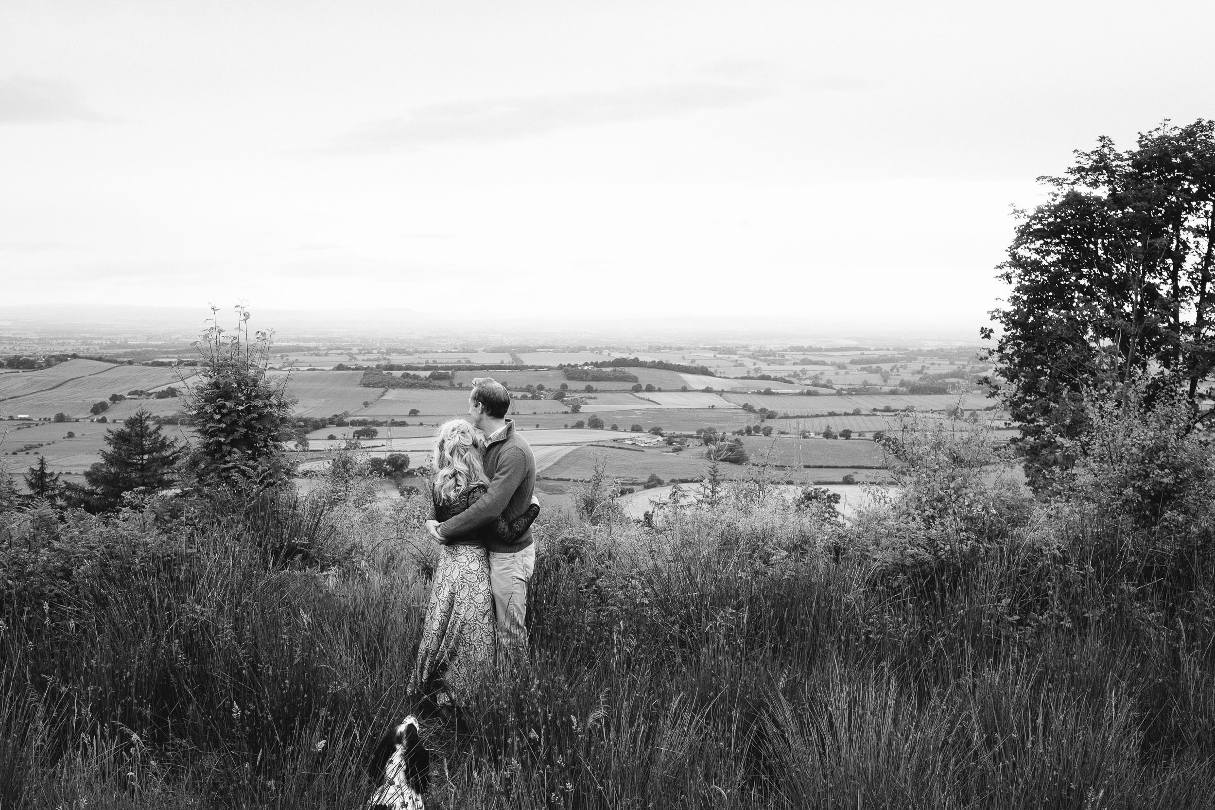 A black and white photo of a couple holding each other looking out over the Yorkshire countryside