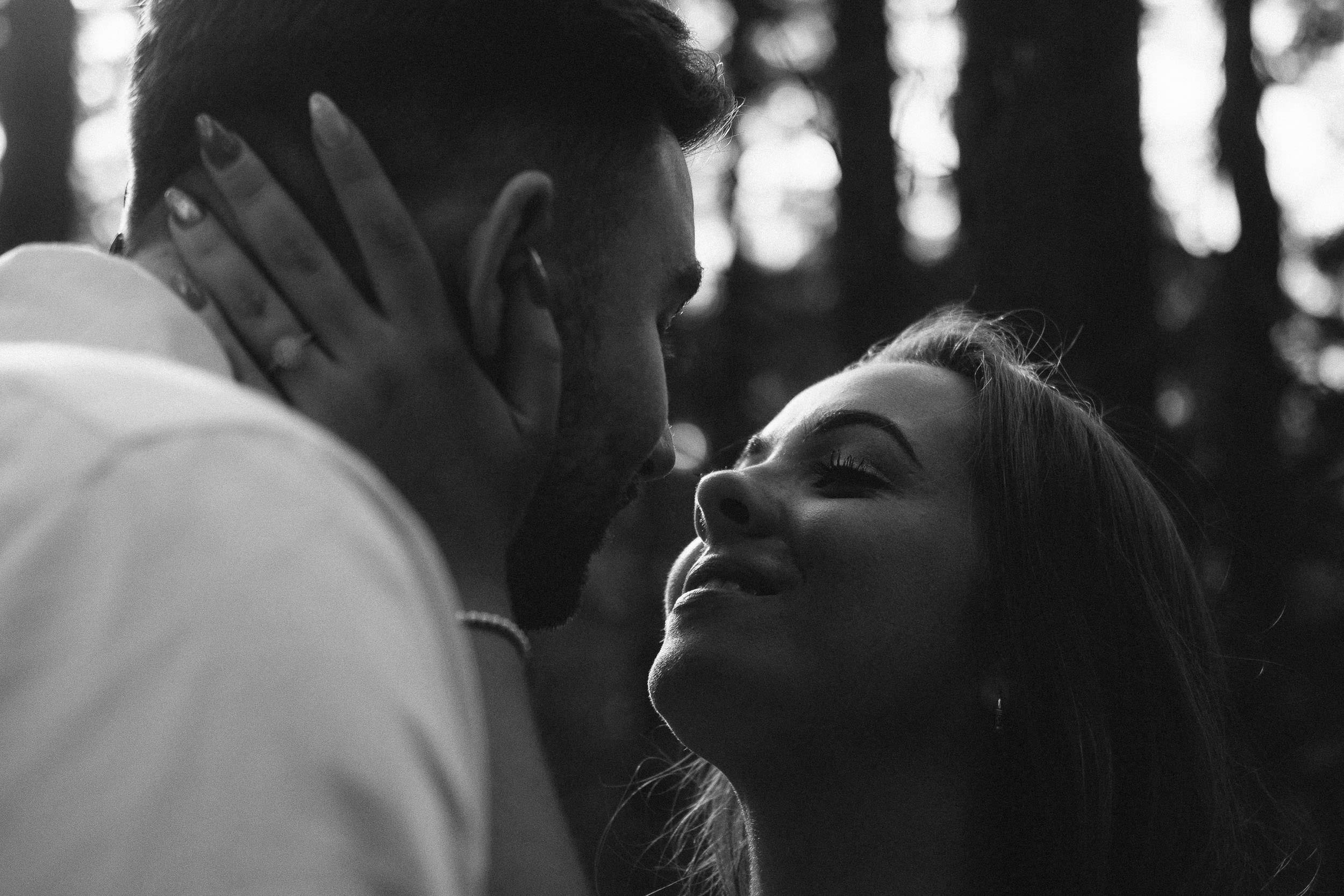 A black and white close up photo of a couple about to kiss