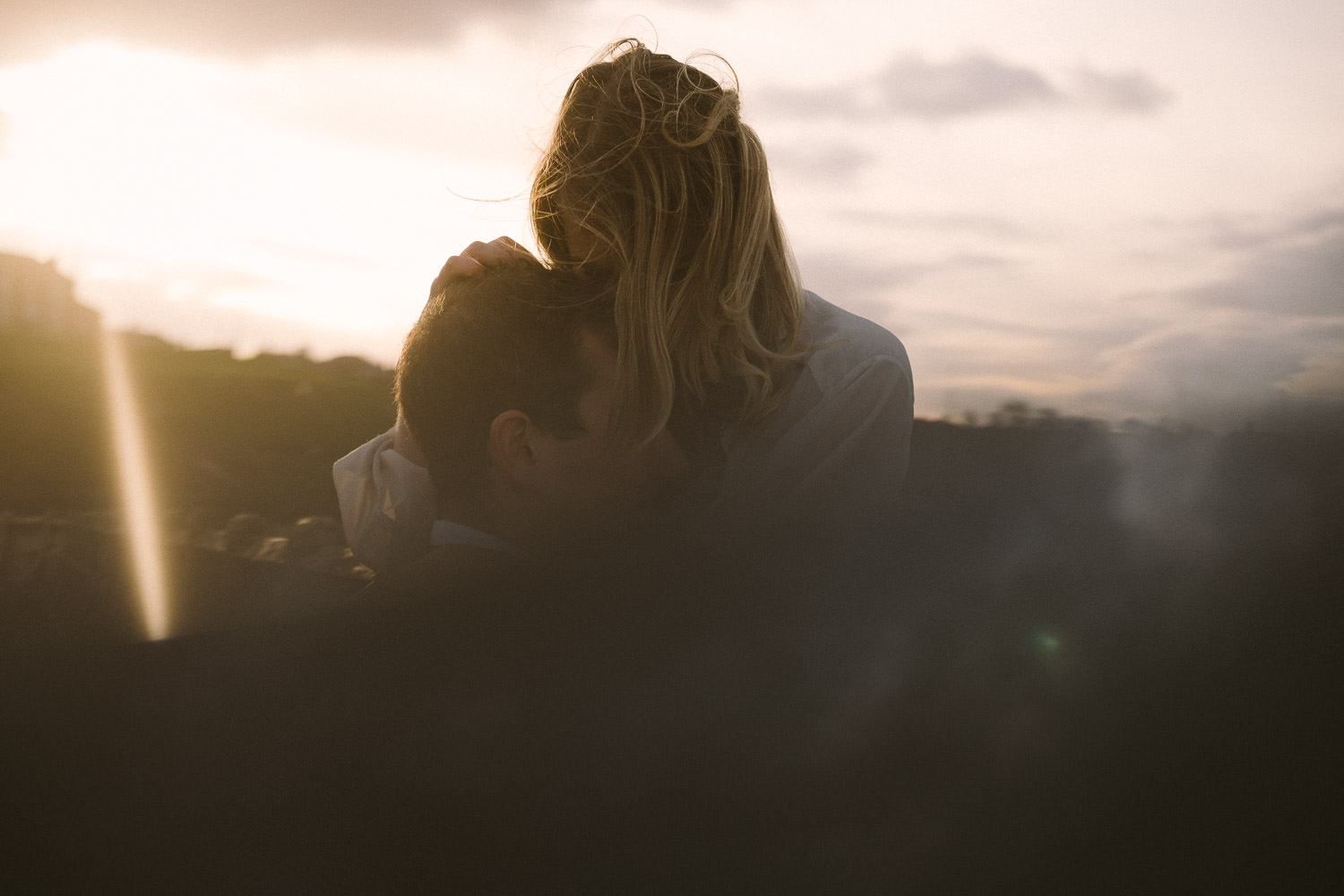 Engaged couple embracing passionately with reflections in prism