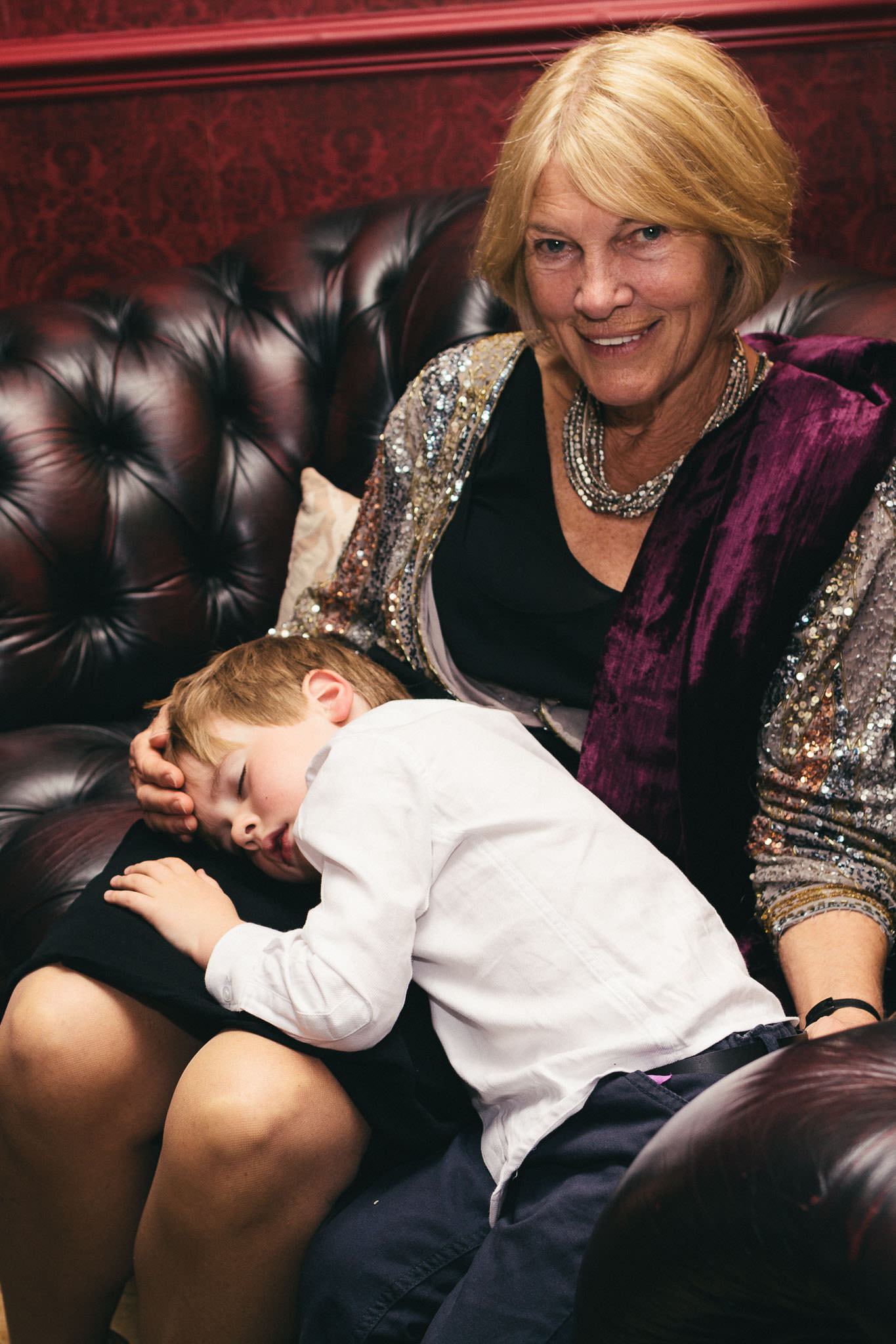 Boy lies asleep in grandma's arms
