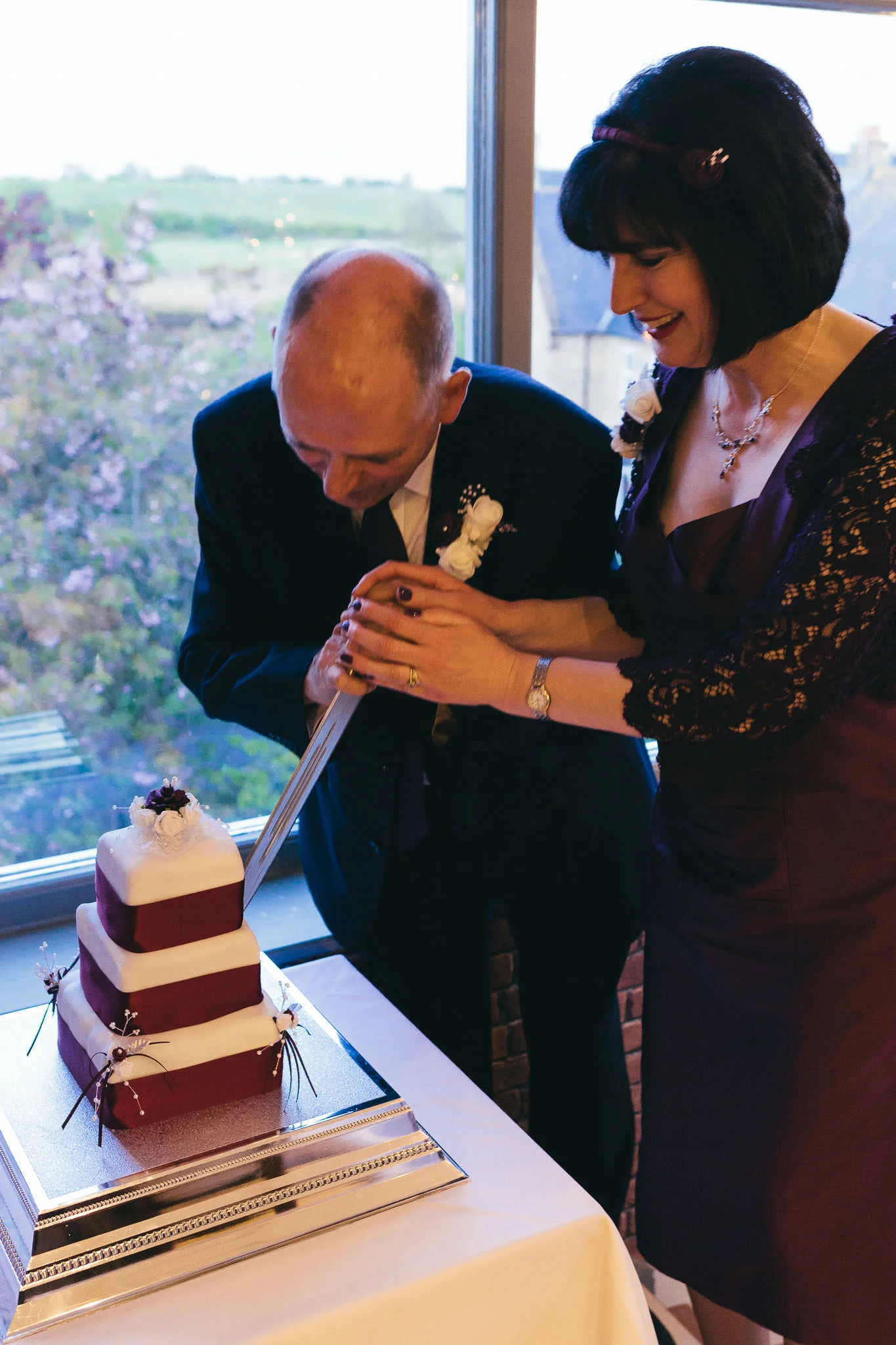 Bride and groom cut cake with sword