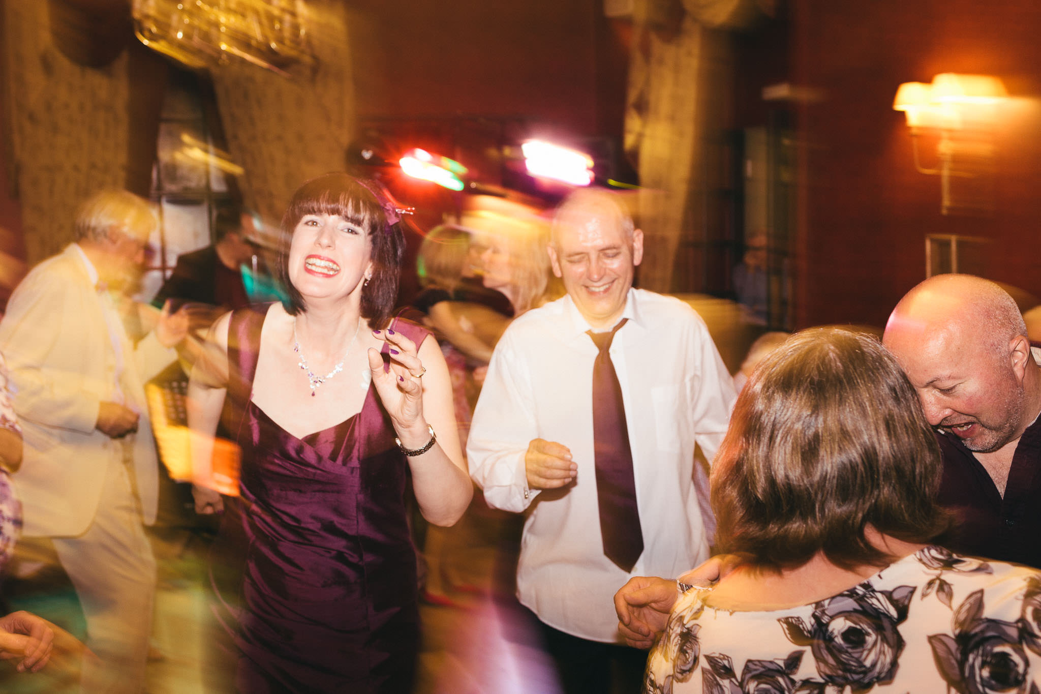 Bride and groom laugh and dance at the end of their wedding night