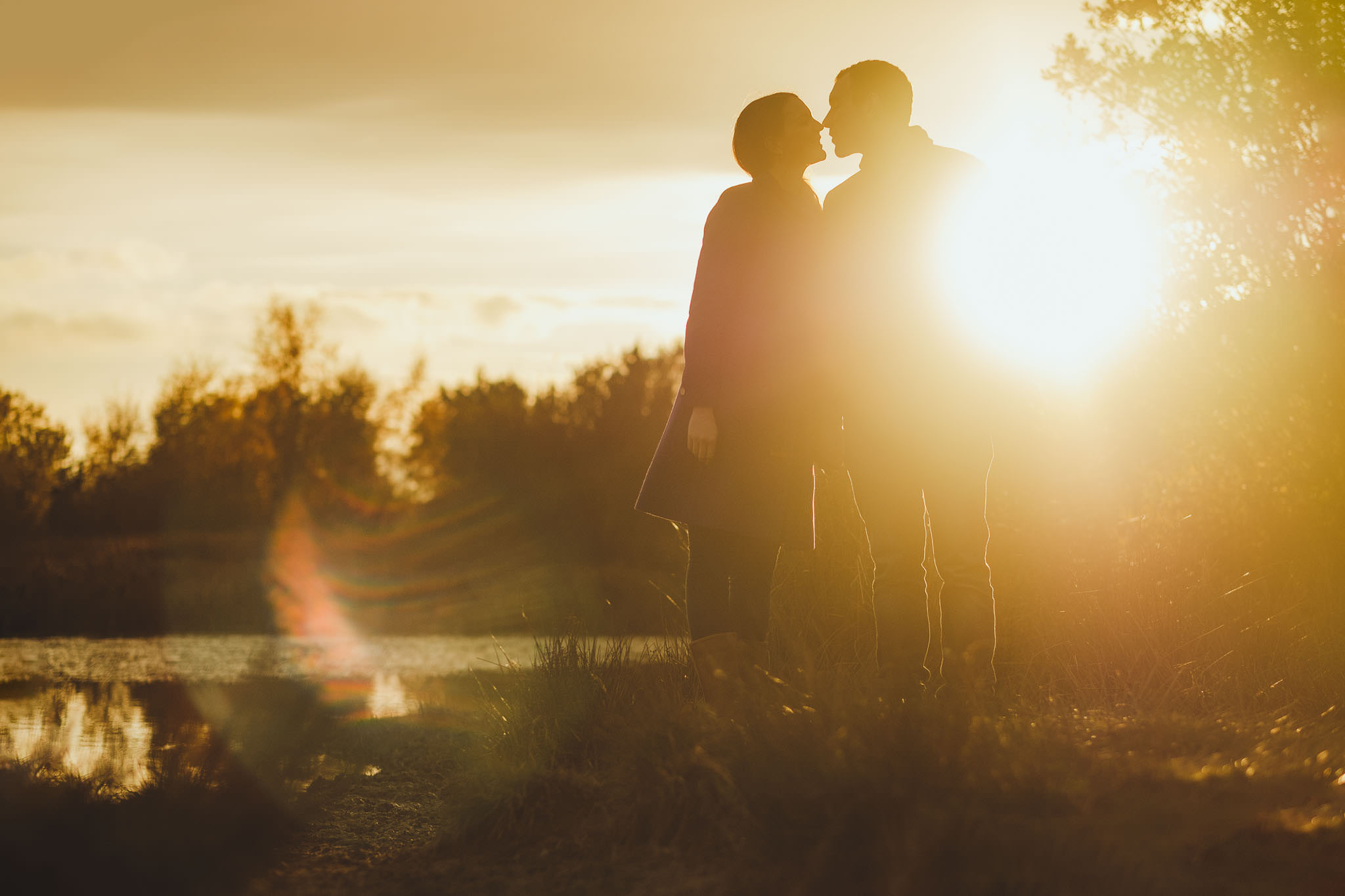 Sunset photo of couple kissing in a nature reserve in Newcastle