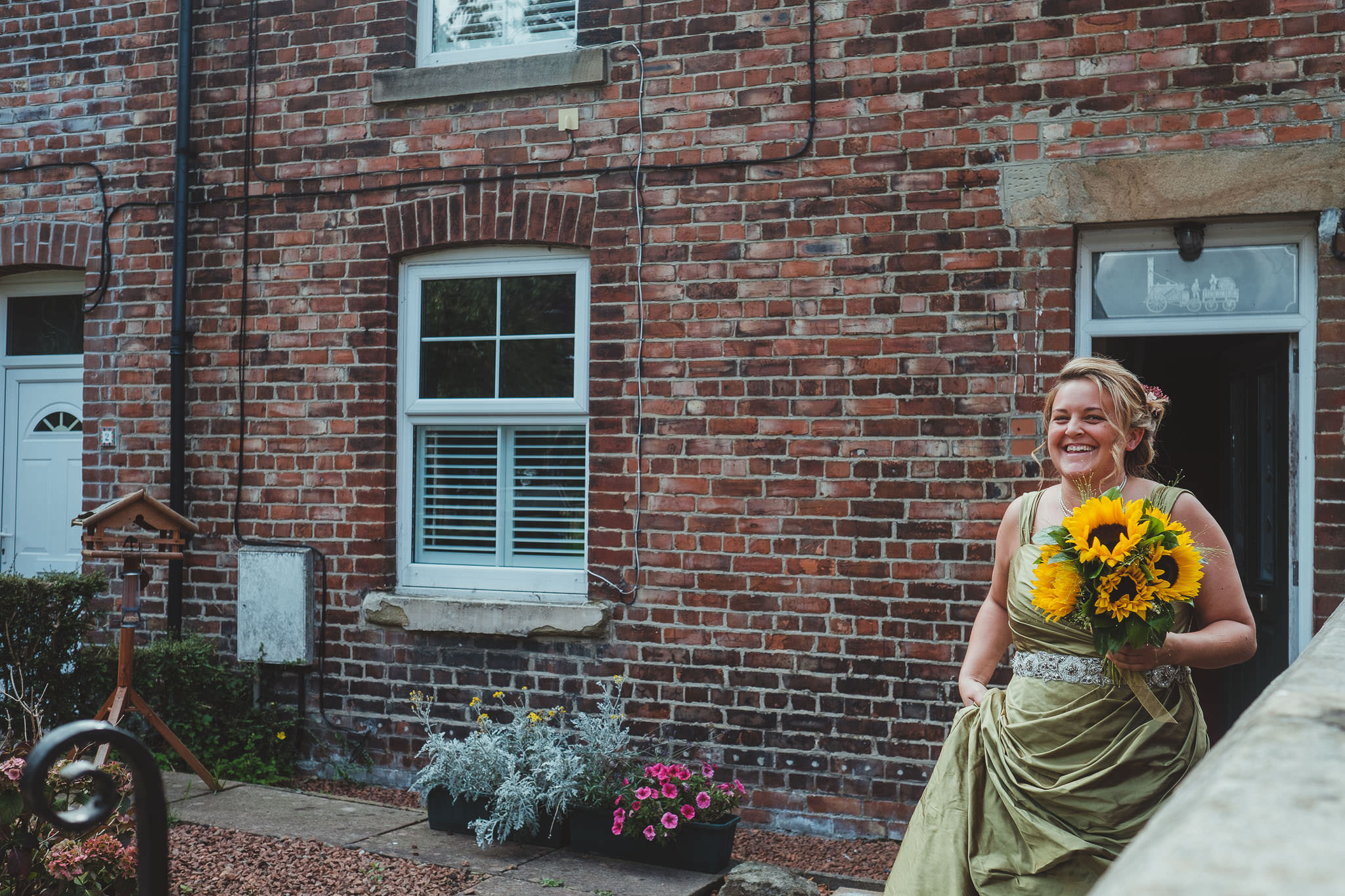 Bride smiling as she leaves her house in Newcastle for the wedding