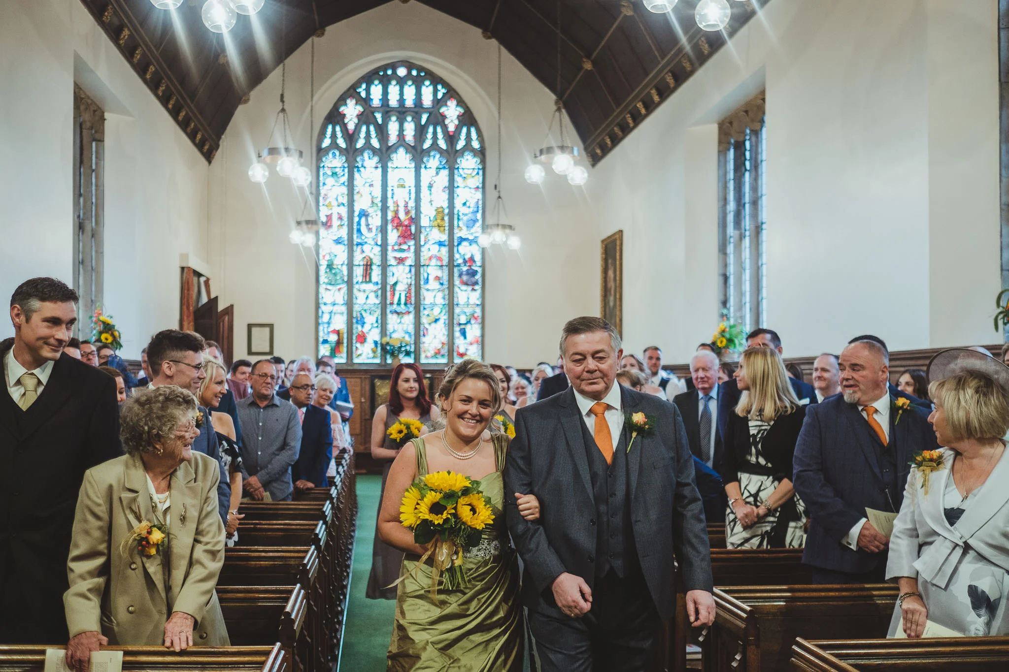 Bride is walked down the aisle of the church by her dad