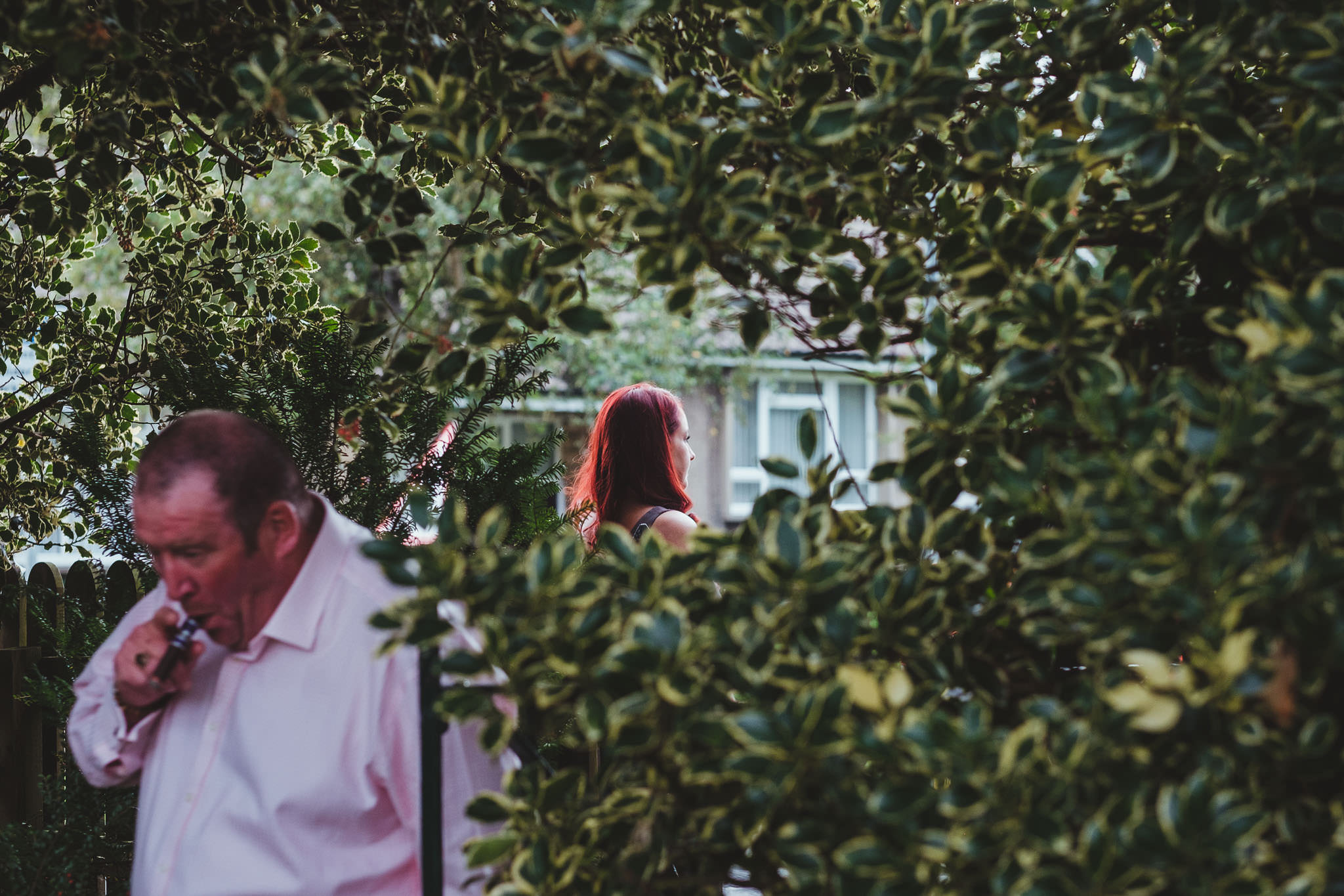 Wedding guests smoking near bushes outside Wylam Institute