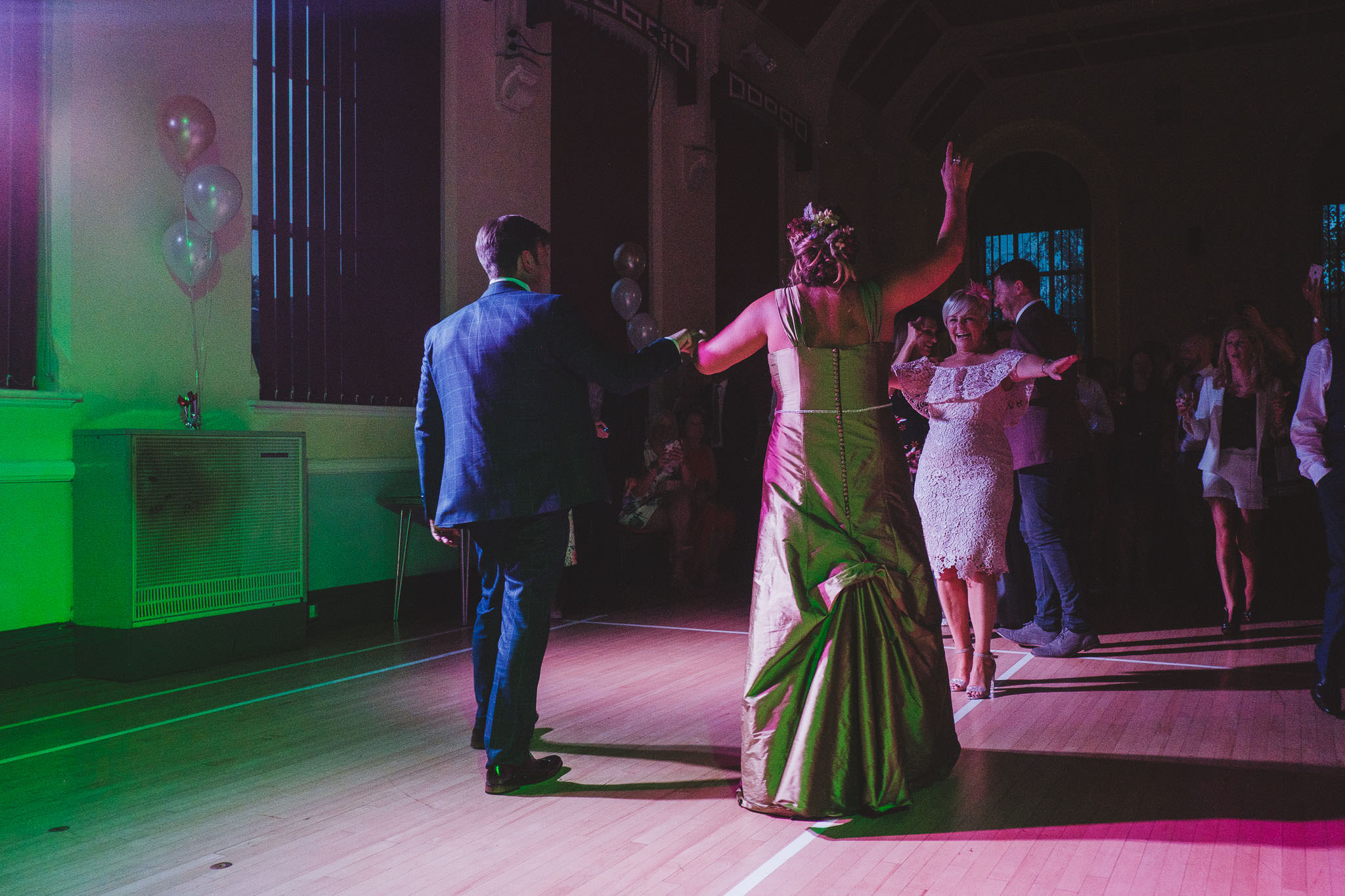 Bride and groom beckon the guests to the dance floor after the first dance