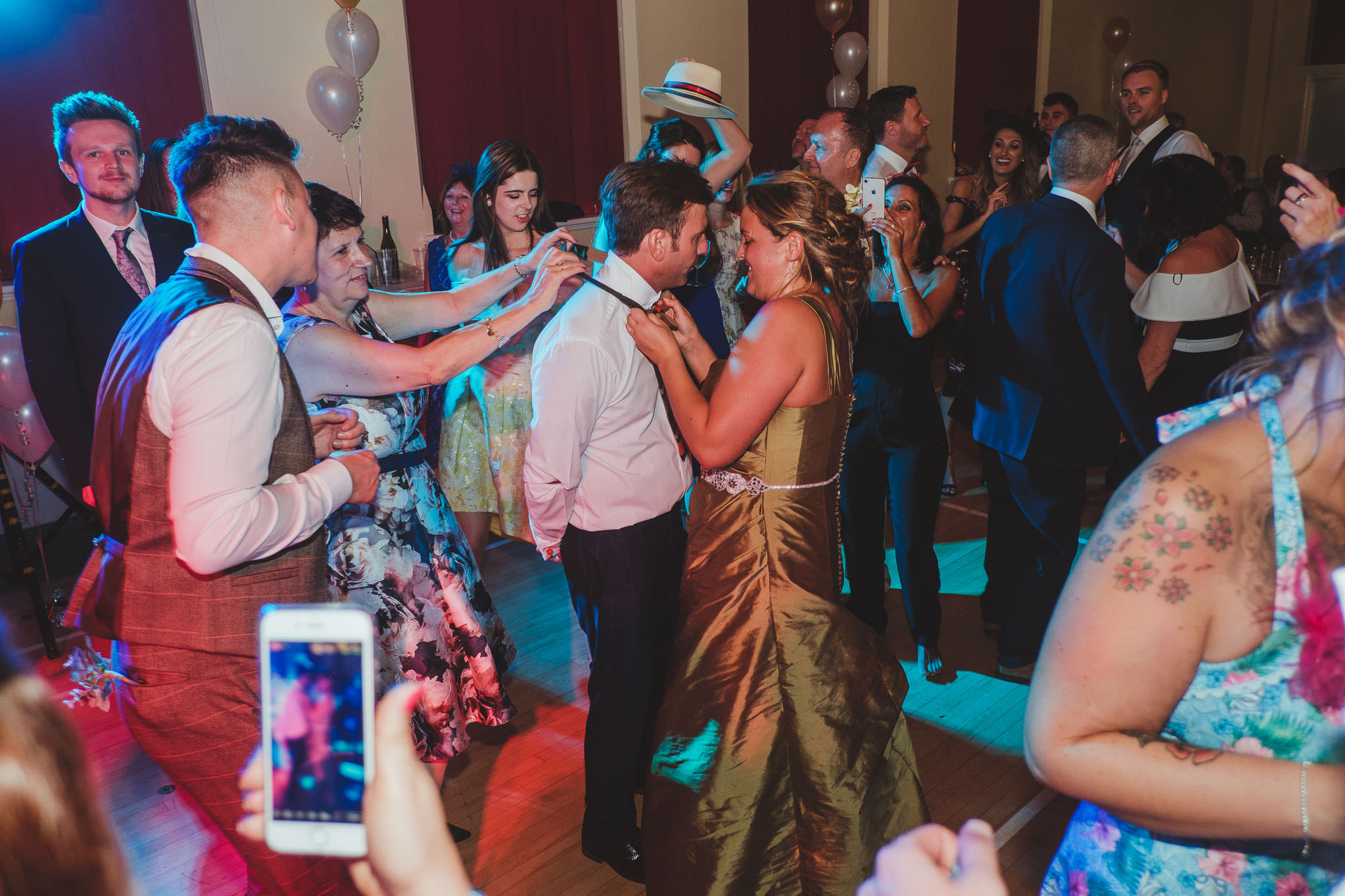 Bride removing the groom's tie at the end of their wedding