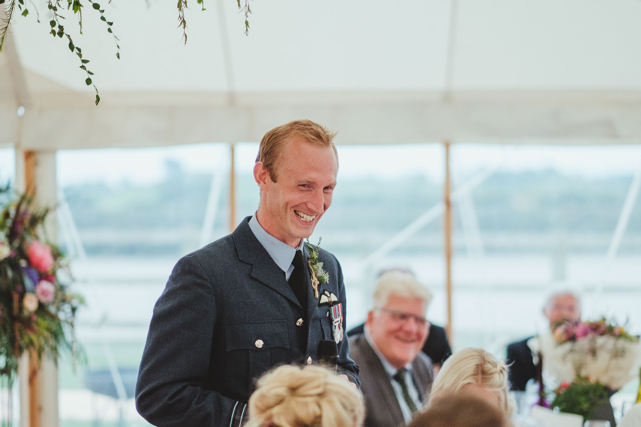 The groom laughing during his wedding speech