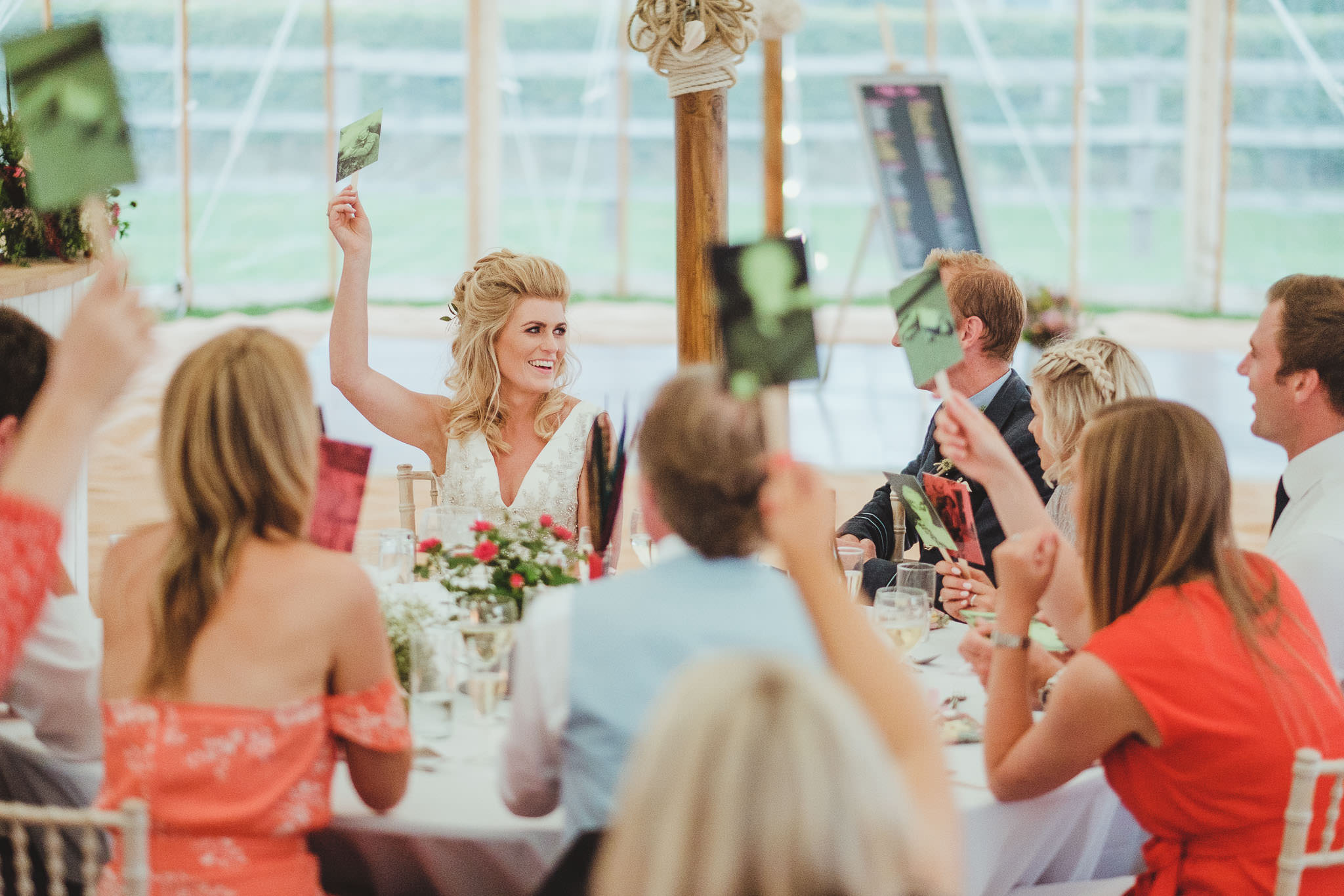 The bride laughs while playing a game during the wedding speeches
