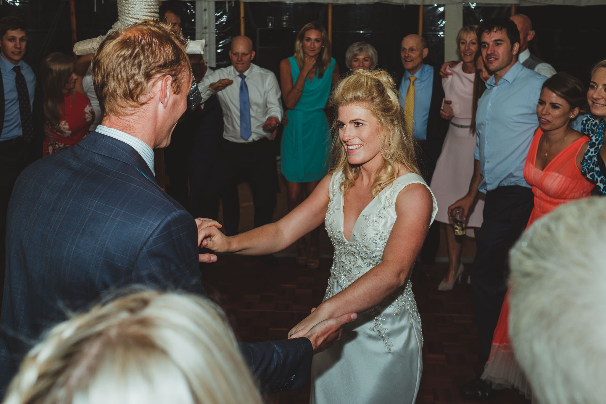 The bride and groom dance while surrounded by their friends