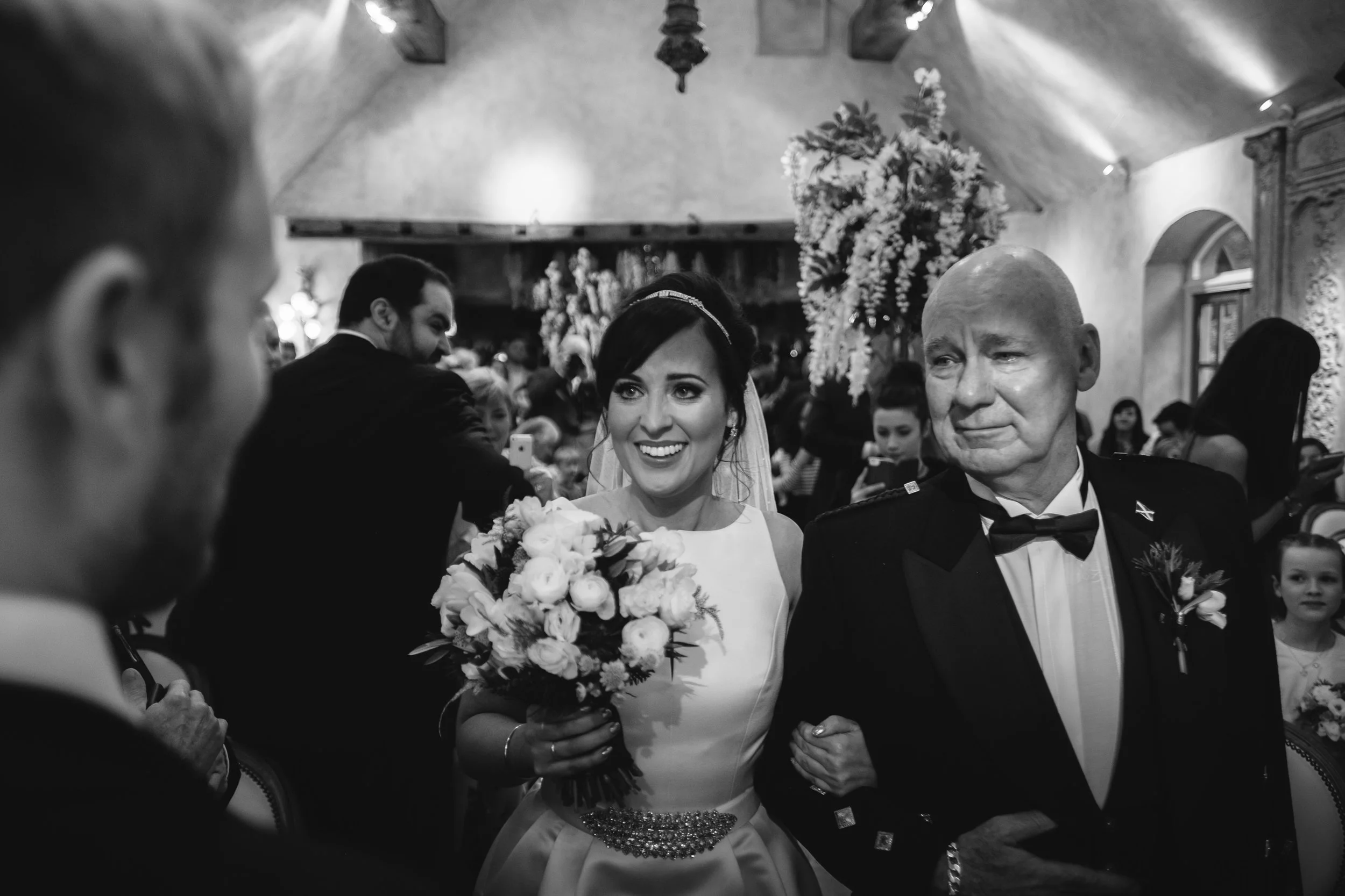 Alex meeting Sam at the end of the aisle arm in arm with her Dad at le Petit Château in Northumberland