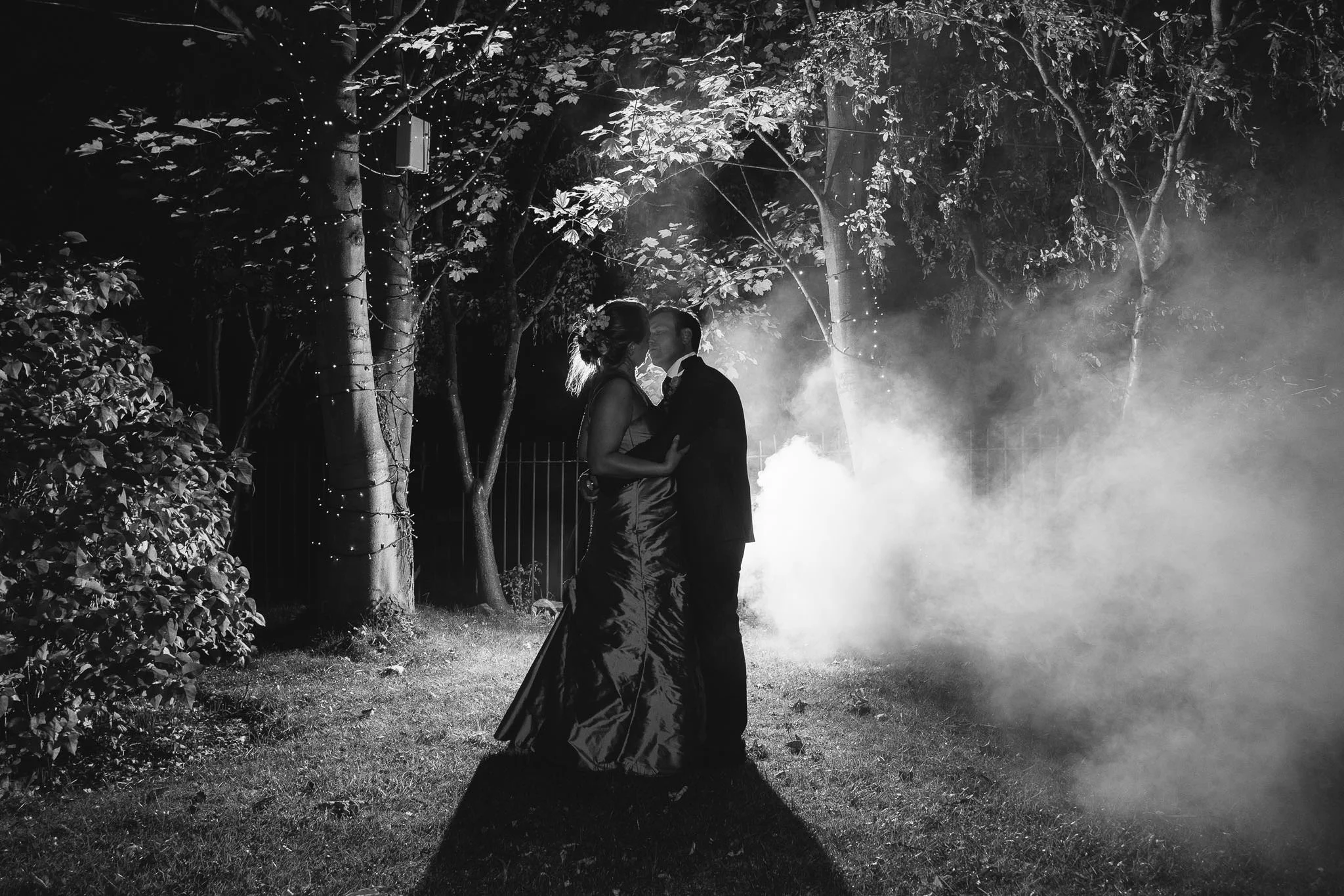 For my night portraits I generally place the flash on a small light stand about 2 metres or so behind the couple, either pointing straight up if there is interesting surroundings, or straight back towards the camera. This gives a strong, dramatic light to the final image. For my first try adding a smoke bomb I popped it behind the couple but in front of the flash.