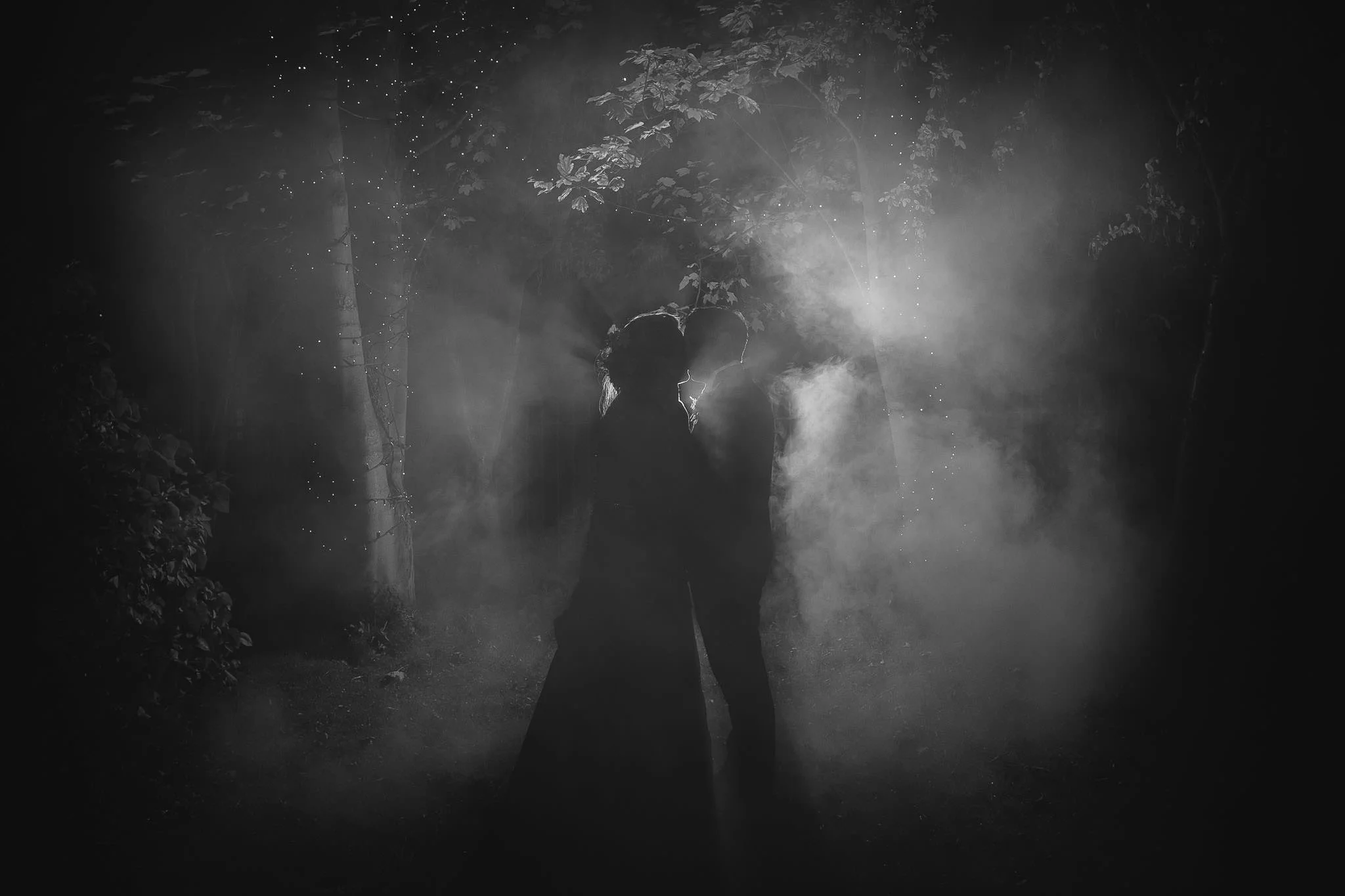 This was my favourite photo of all the ones I took. The flash made the couple into silhouettes, with a strongly defined rim light. The flash is punching through the smoke and giving a very romantic and dreamy mood. Combined with the twinkling strings of fairy lights and the trees it works very well to transform a tiny corner of a Mining Institute garden into something magical.