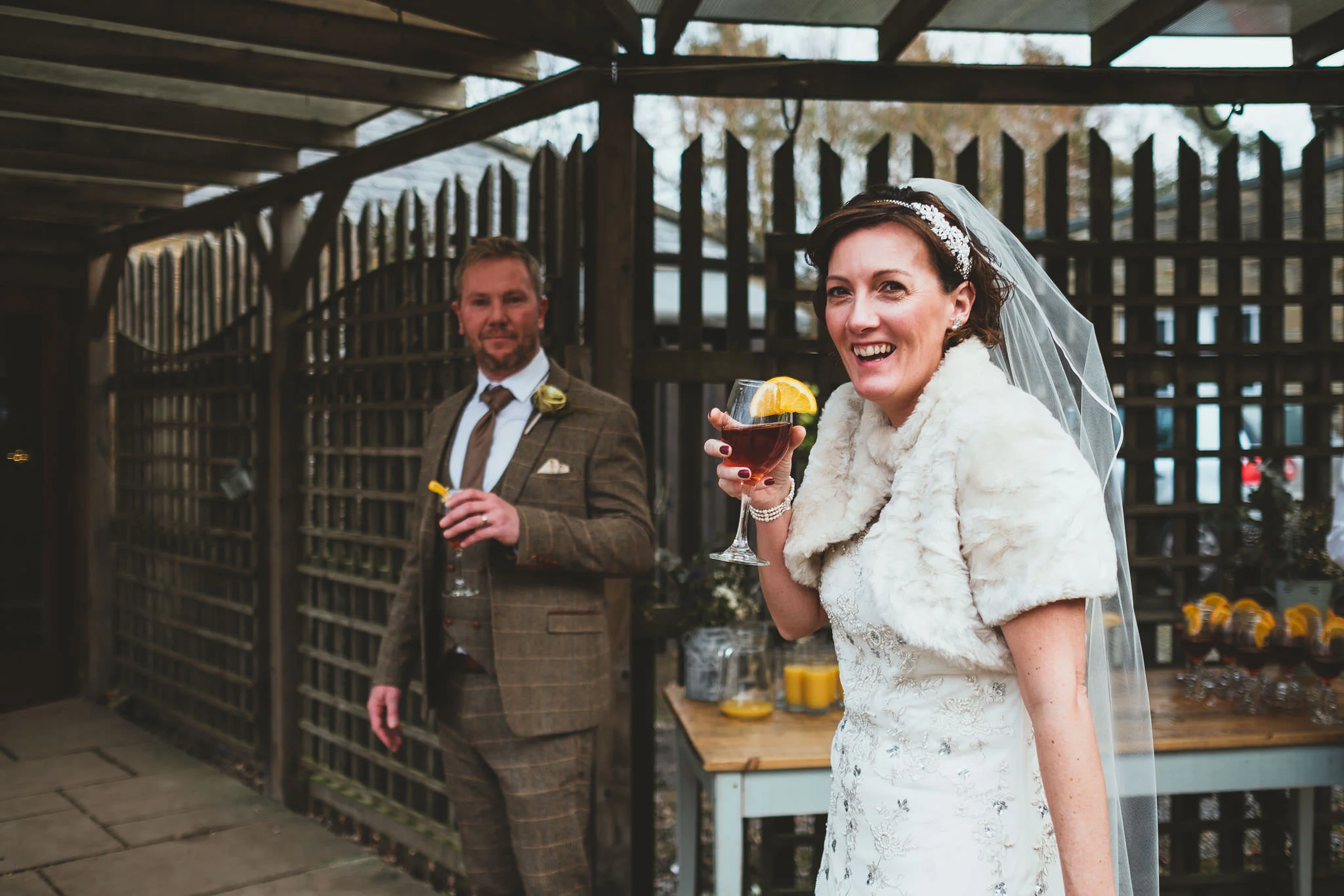 Bride smiles at camera while holding cocktail
