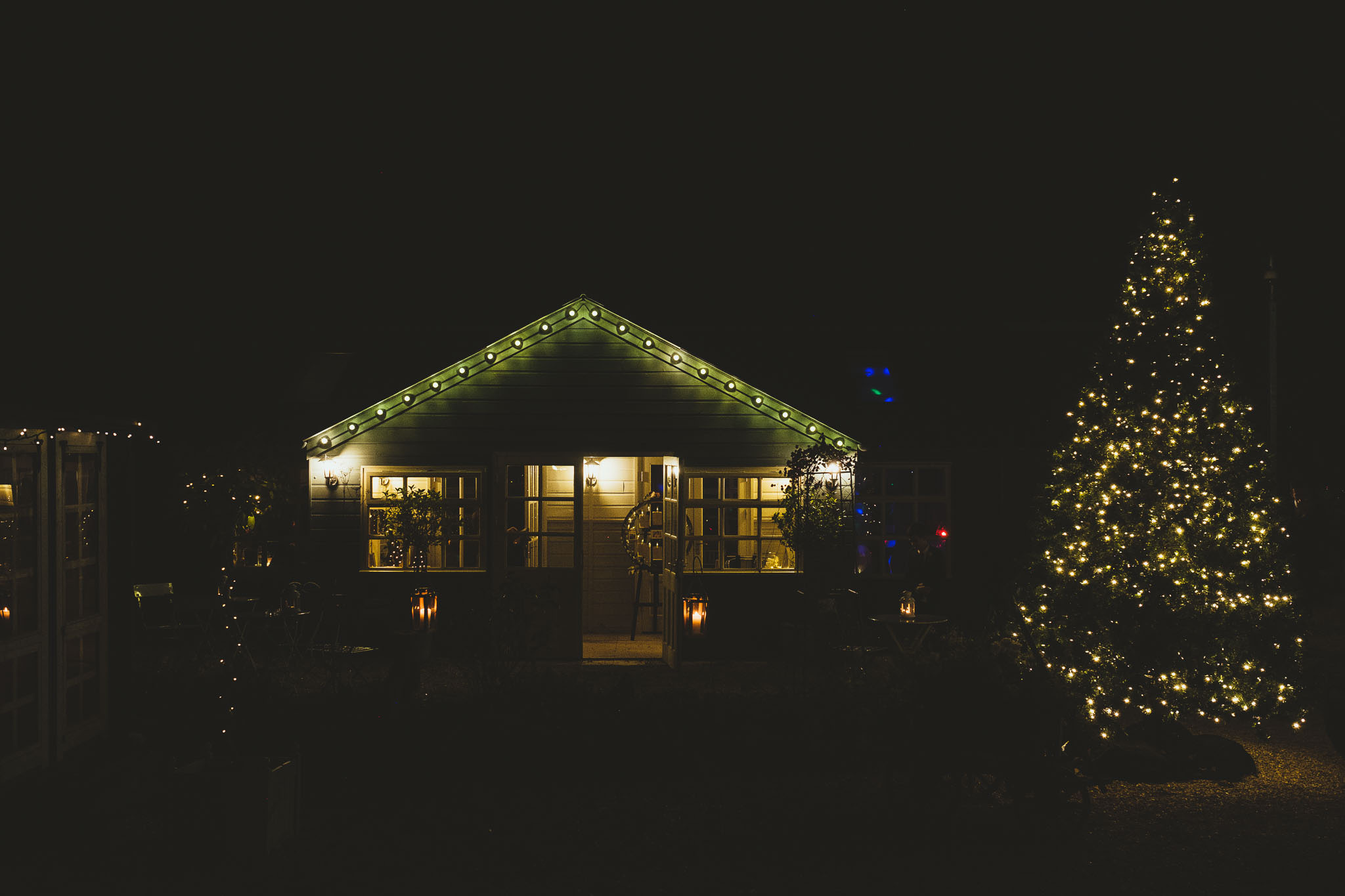 The courtyard of The Parlour at Blagdon lit by a Christmas tree and fairy lights at night