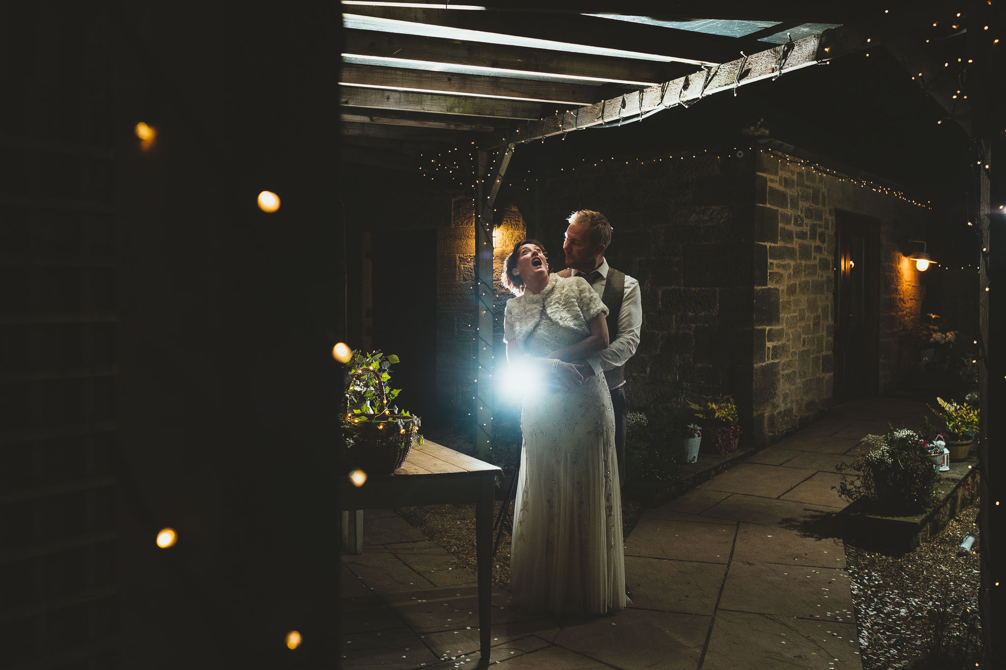 Funny nighttime portrait of bride and groom pulling faces