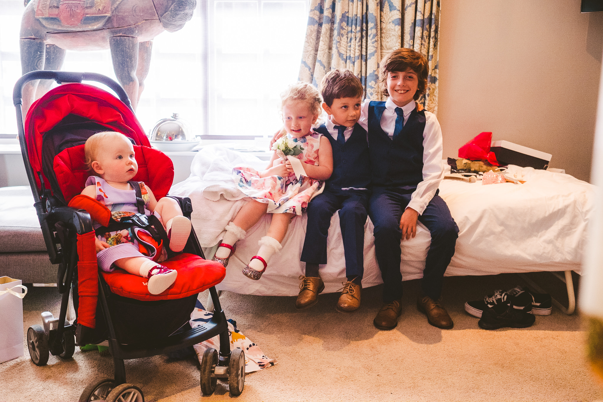 Children sitting on a bed ready for the wedding