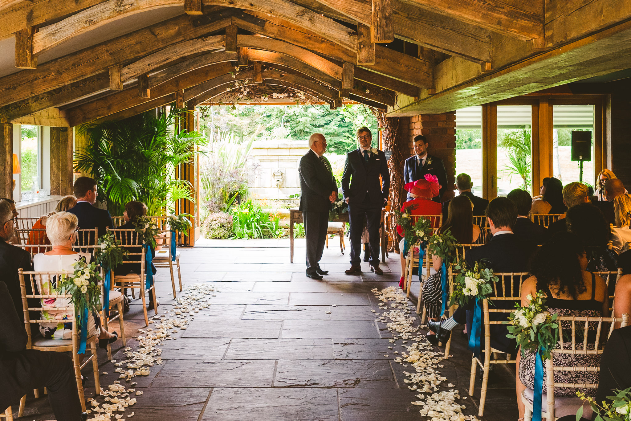 Groom waiting at the end of the aisle before his ceremony in the Garden Suite at Newton Hall
