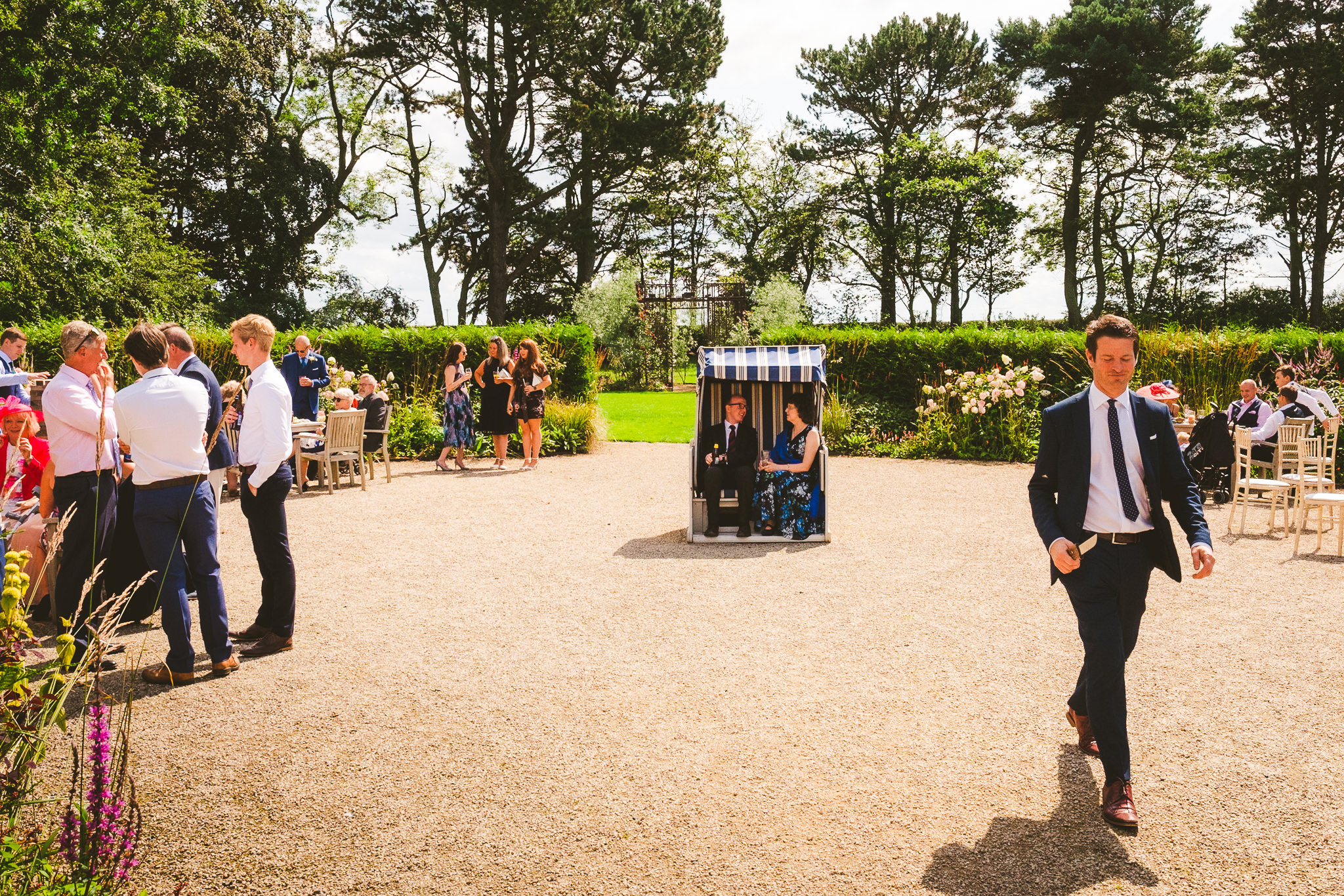 The magician walks across the yard at Newton Hall while holding a knife