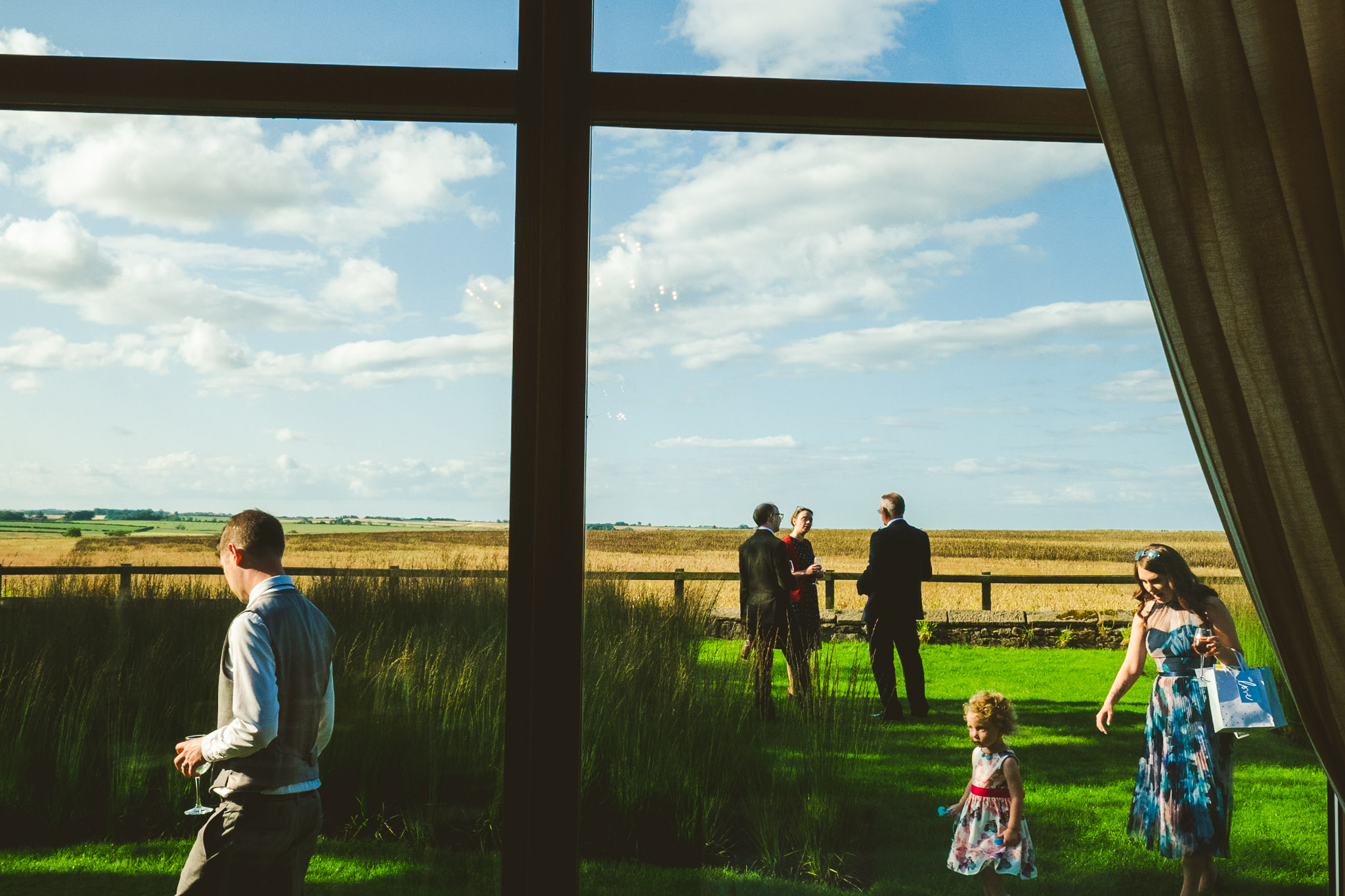 Guests walk by the windows outside Newton Hall