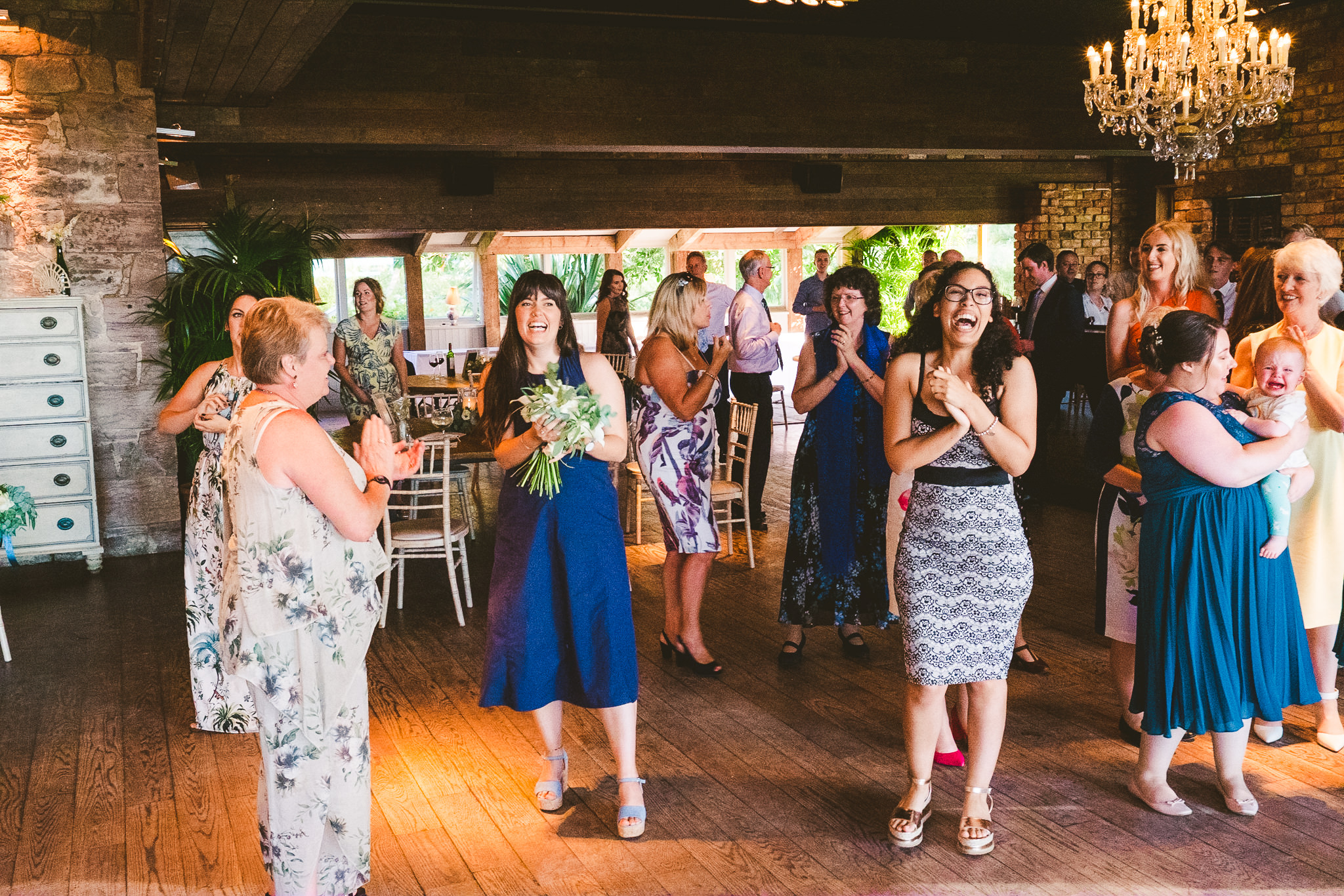 Guests laugh after the Bouquet toss at Newton Hall