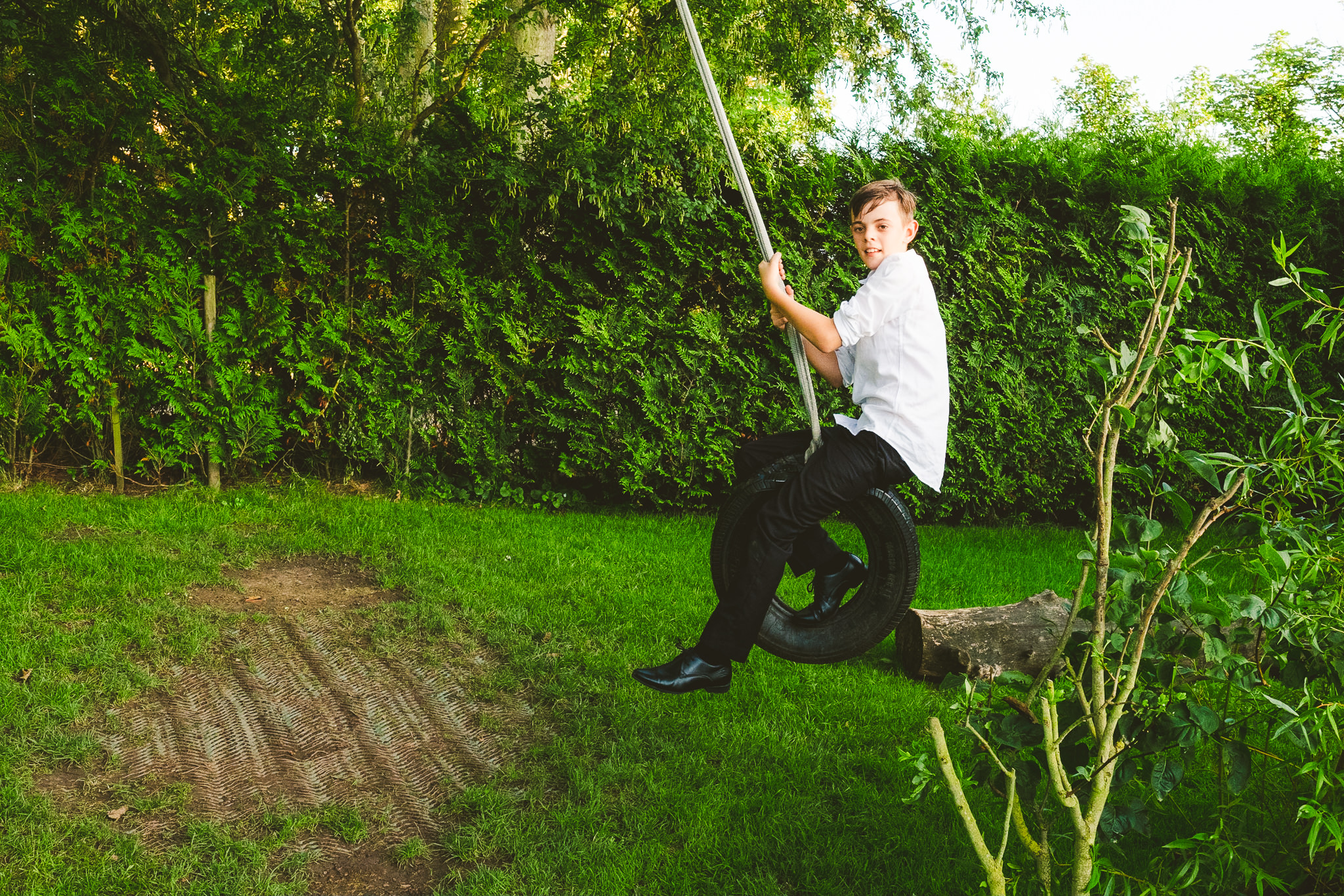 Boy plays on tyre swing at Newton Hall