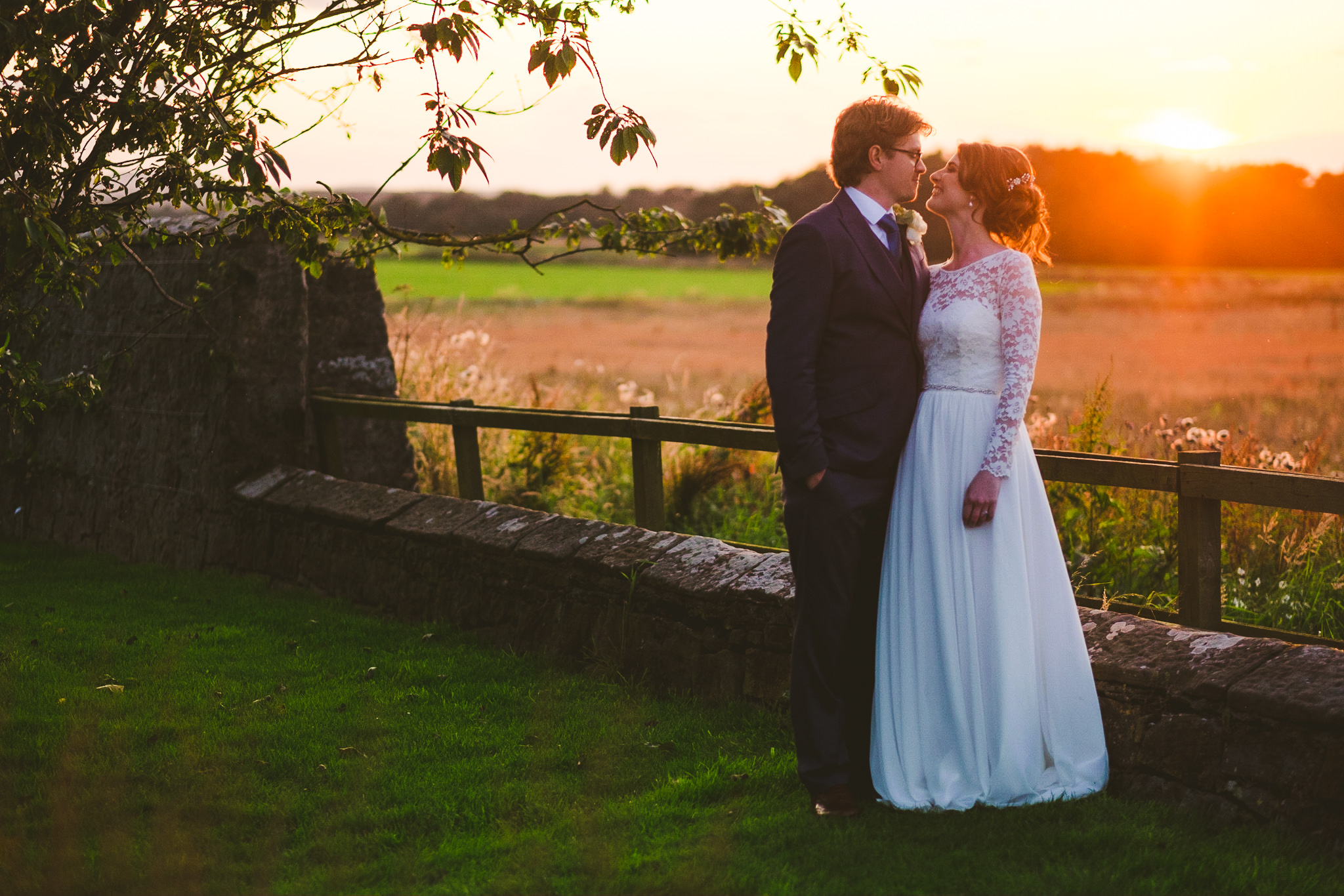 Bride and groom kiss at sunset at Newton Hall