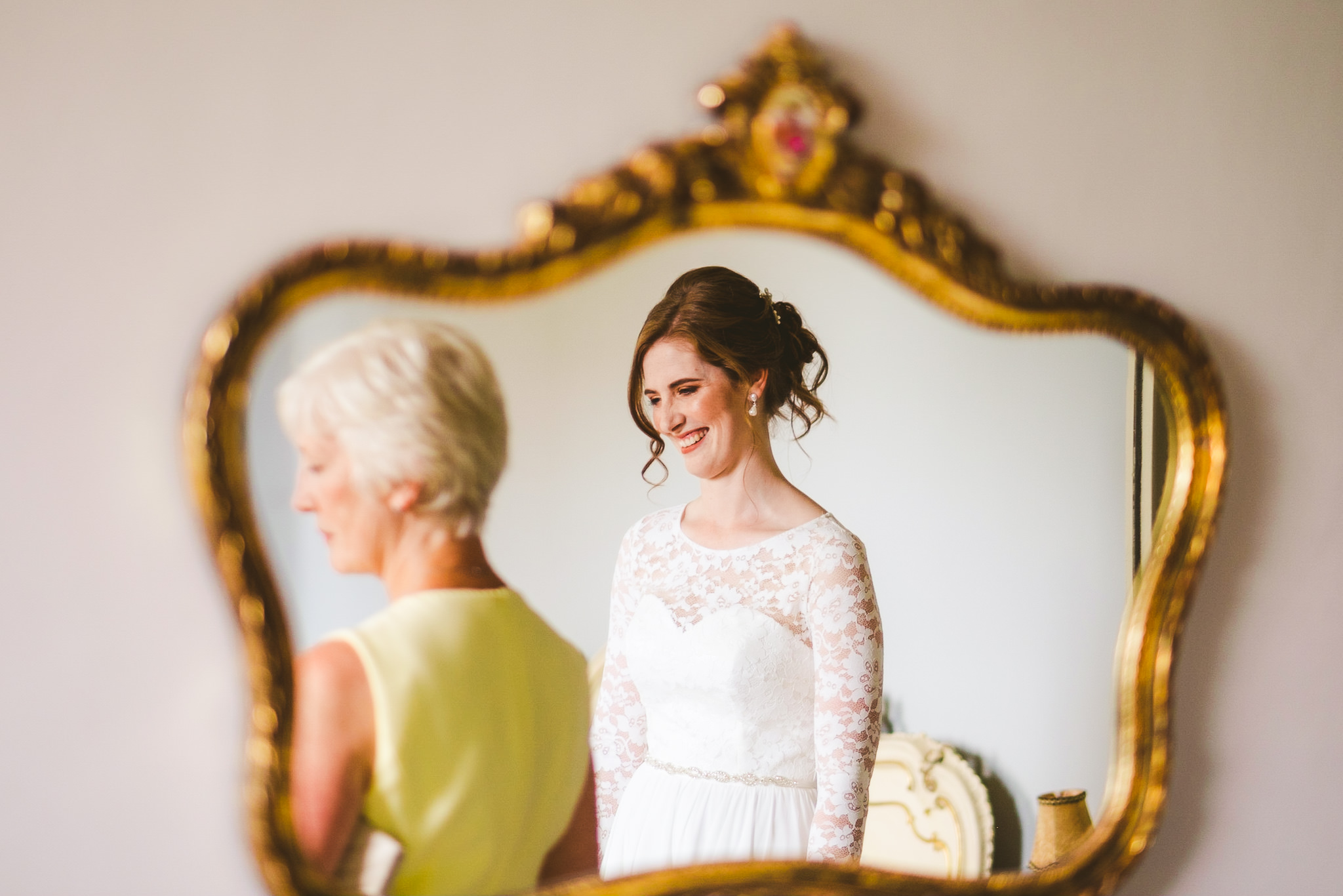 Bride and her mother reflected in a mirror before the ceremony