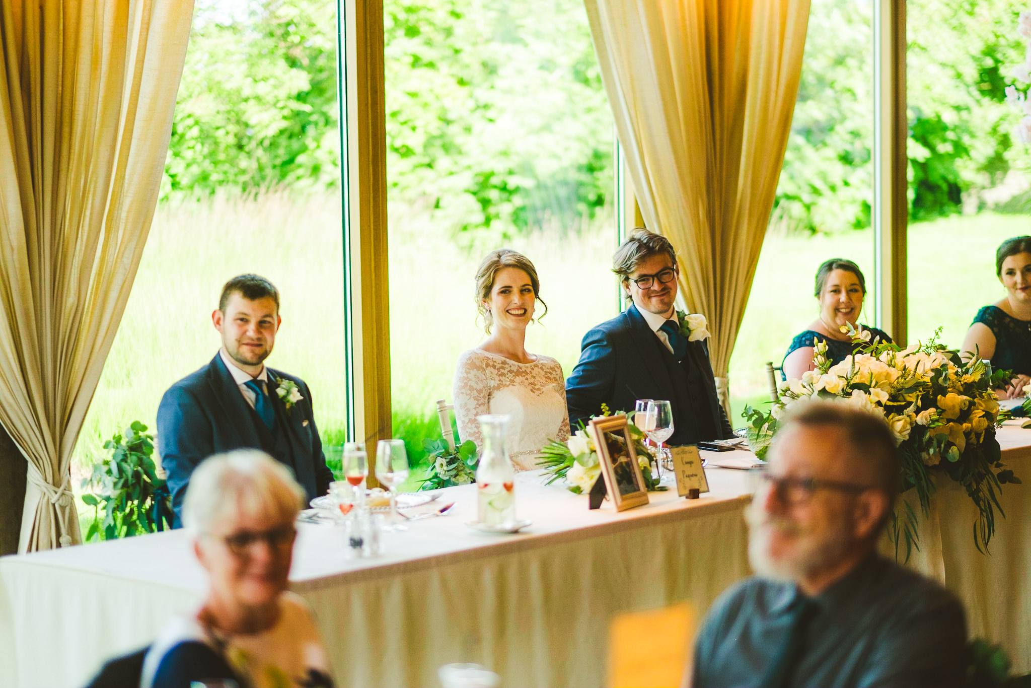 Bride and groom laugh at wedding speech
