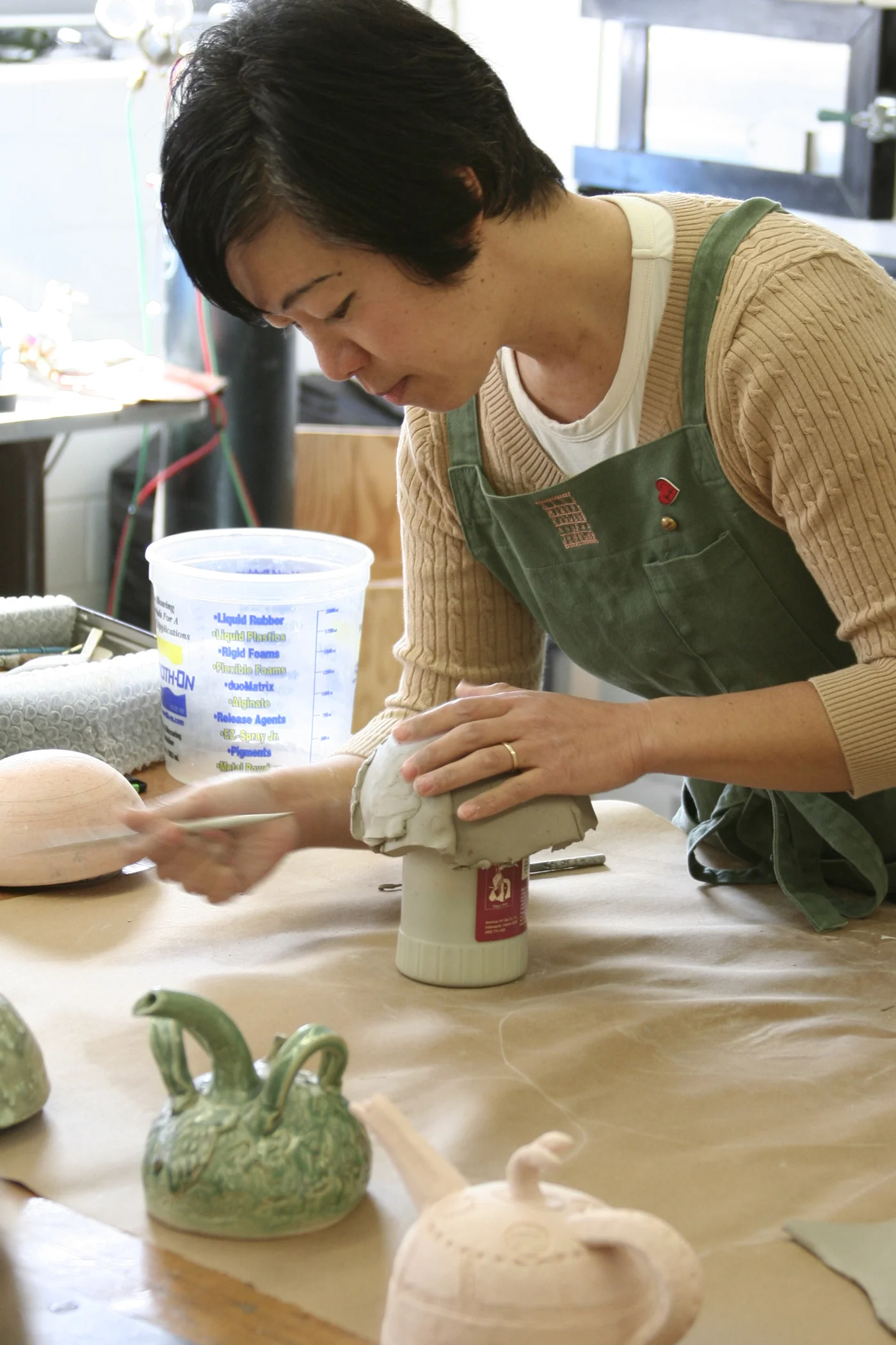 Covering the mold with a sheet of clay, adjusting the drapes