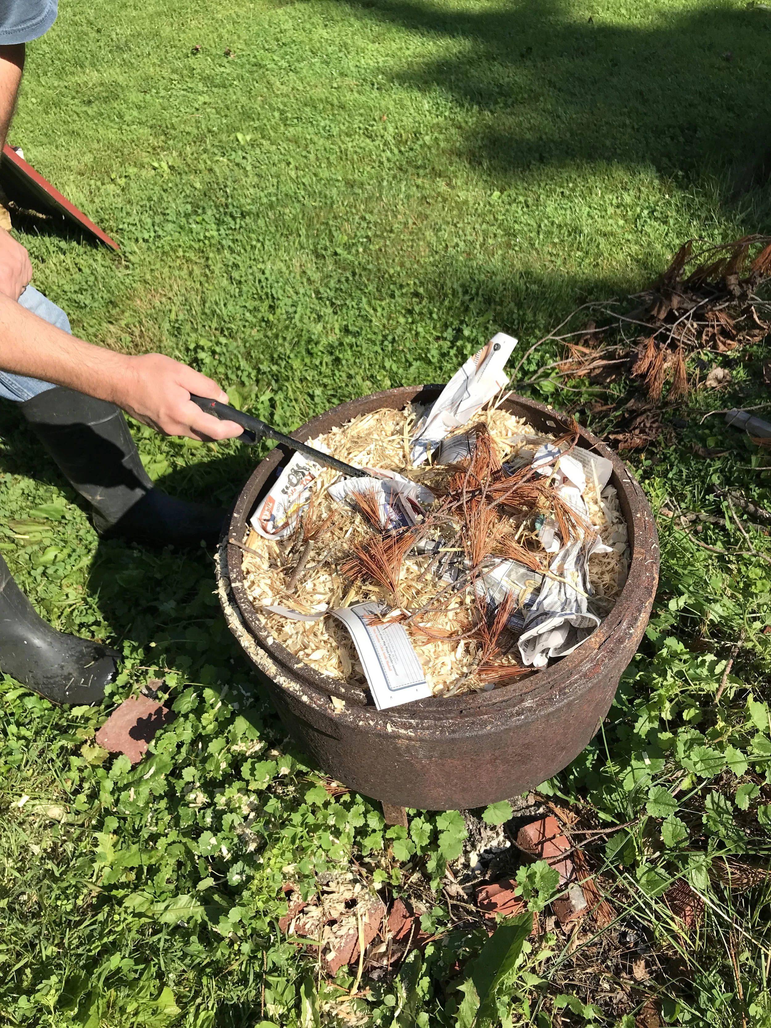 2. Cover the Pots and Start the Fire Cover your pots with combustible materials, then light the fire. Maintain a small, steady flame for at least 30 minutes to ensure the pots are properly exposed to heat.