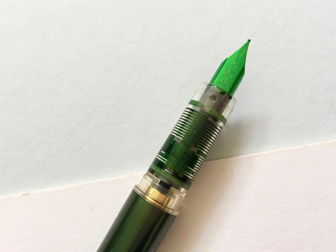 The luminous green nib and the clear plastic grip section.