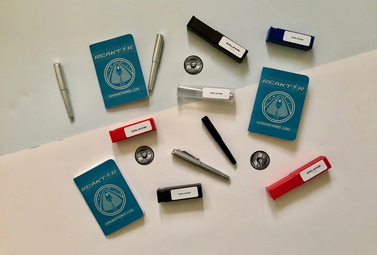 Everything that makes up the Reaktor line of pens: Galaxie pen, packaging, notebooks and stickers 