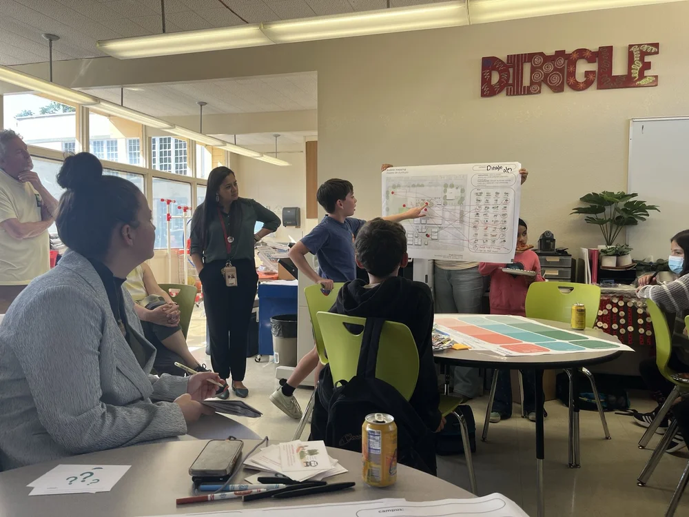 Students present their design, which included tables under a grove of existing trees, swings, and pollinator garden that are being included in the built project. 