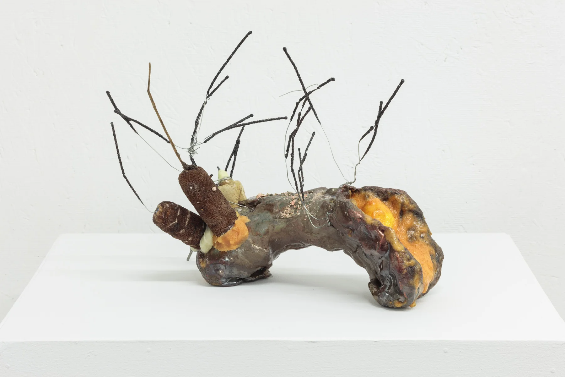 “F(akakt)ocaccia ,” Giordano, 2016 - 2019. Glazed ceramic, Orange Tang, epoxy resin, artificial kumquat, cattails, nail polish, sparklers, shellac, leather, steel, wire hanger, contact lenses, bald eagle excrement, 13 x 10 x 10.5 inches. Photo courtesy of the artist and SARDINE.